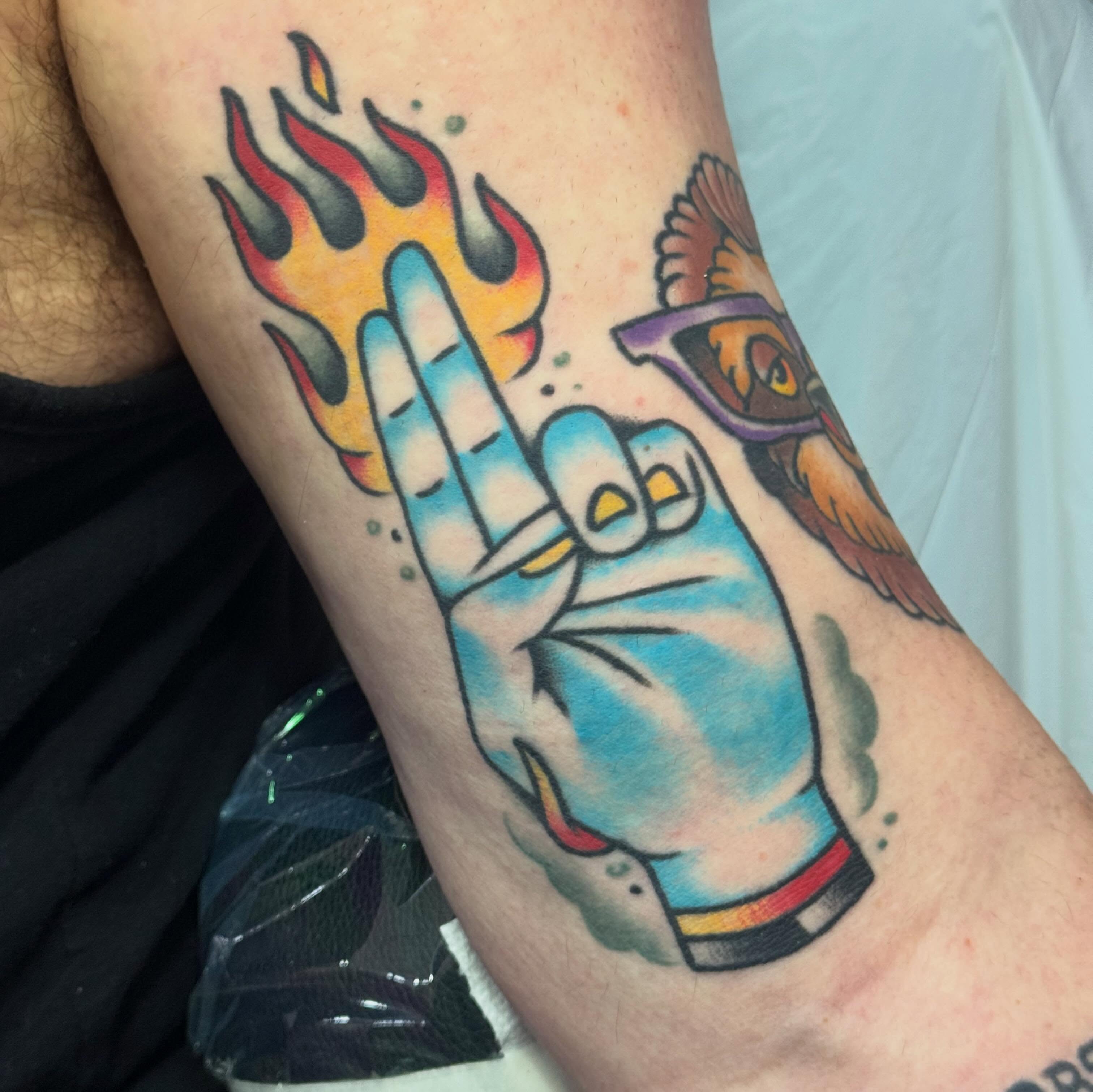 Flaming hand gesture American traditional tattoo on the forearm by Larry Love