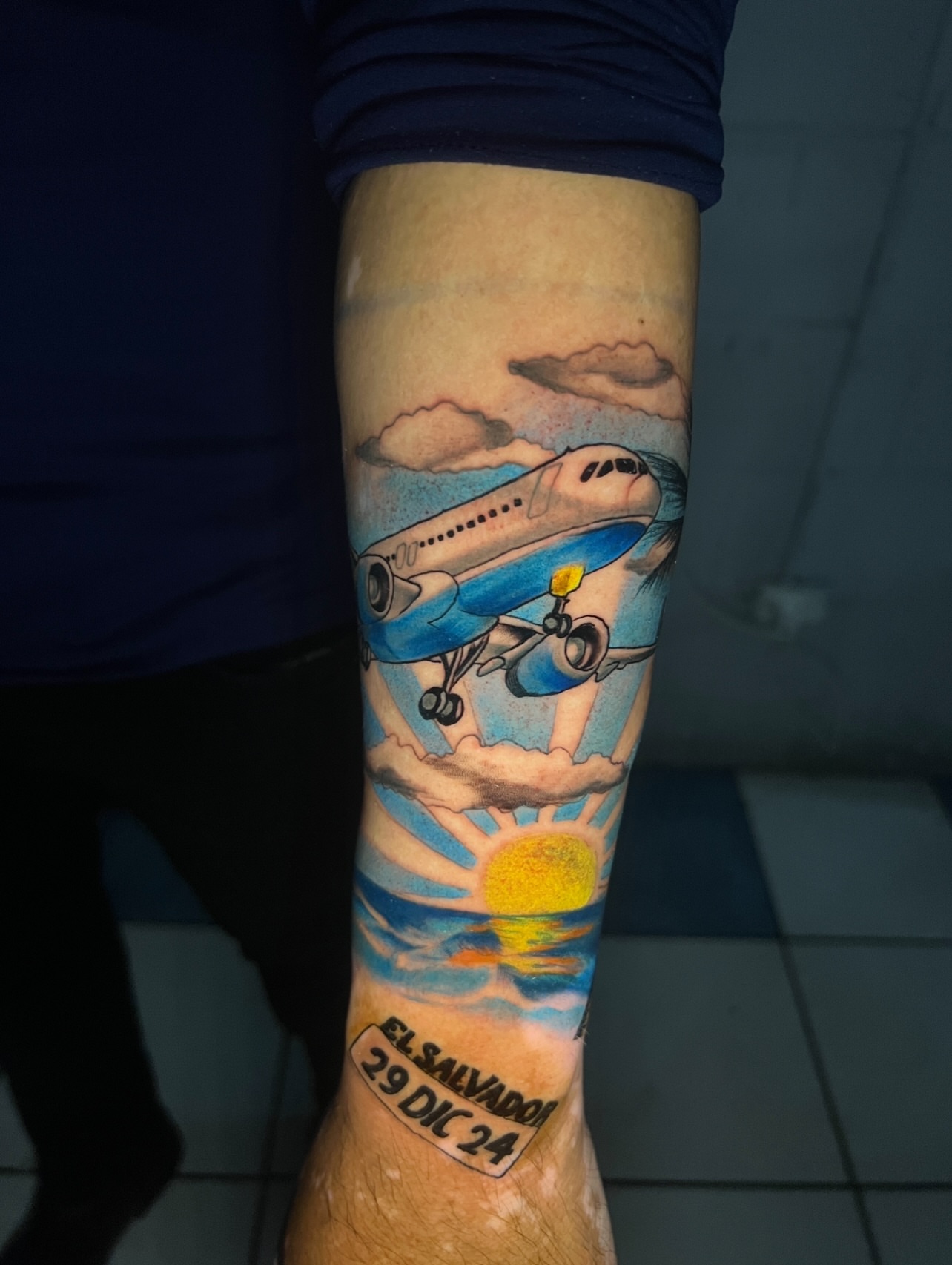 Airplane and sun dotwork tattoo on the forearm by El Salvador Tattoo Artist