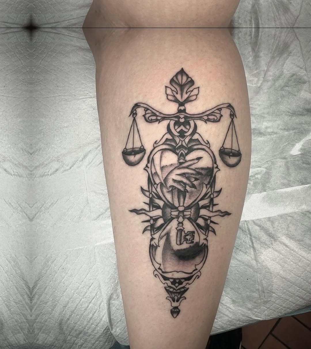 Ornate hourglass with scales and key sketch tattoo on the forearm by Murl Dietrich