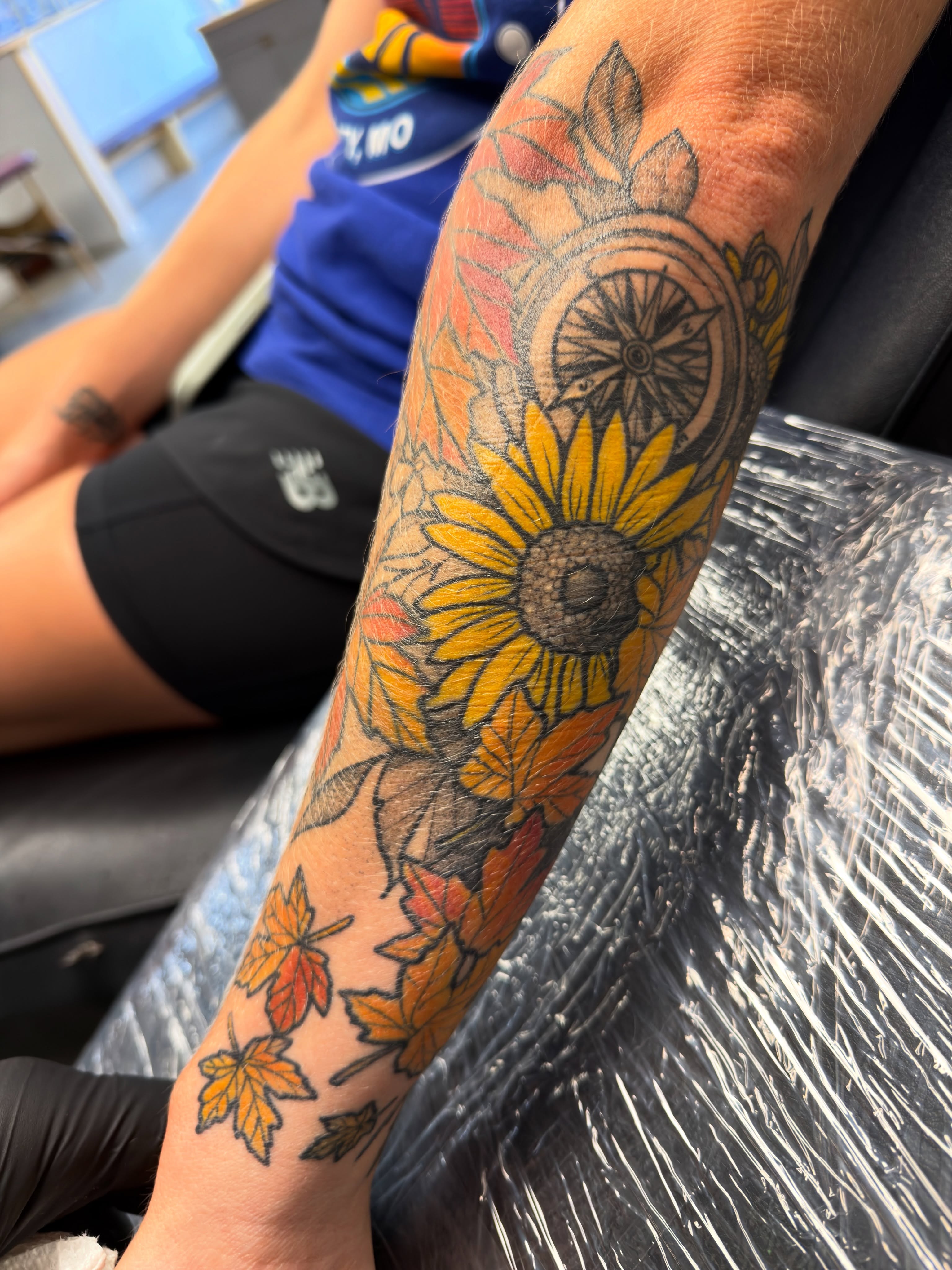 Sunflower and autumn leaves American traditional tattoo on the forearm by Christopher Layman