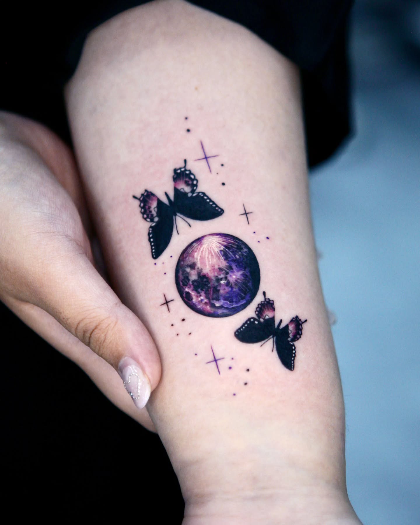 Galaxy and butterflies dotwork tattoo on the forearm by danha_seoul tattooist