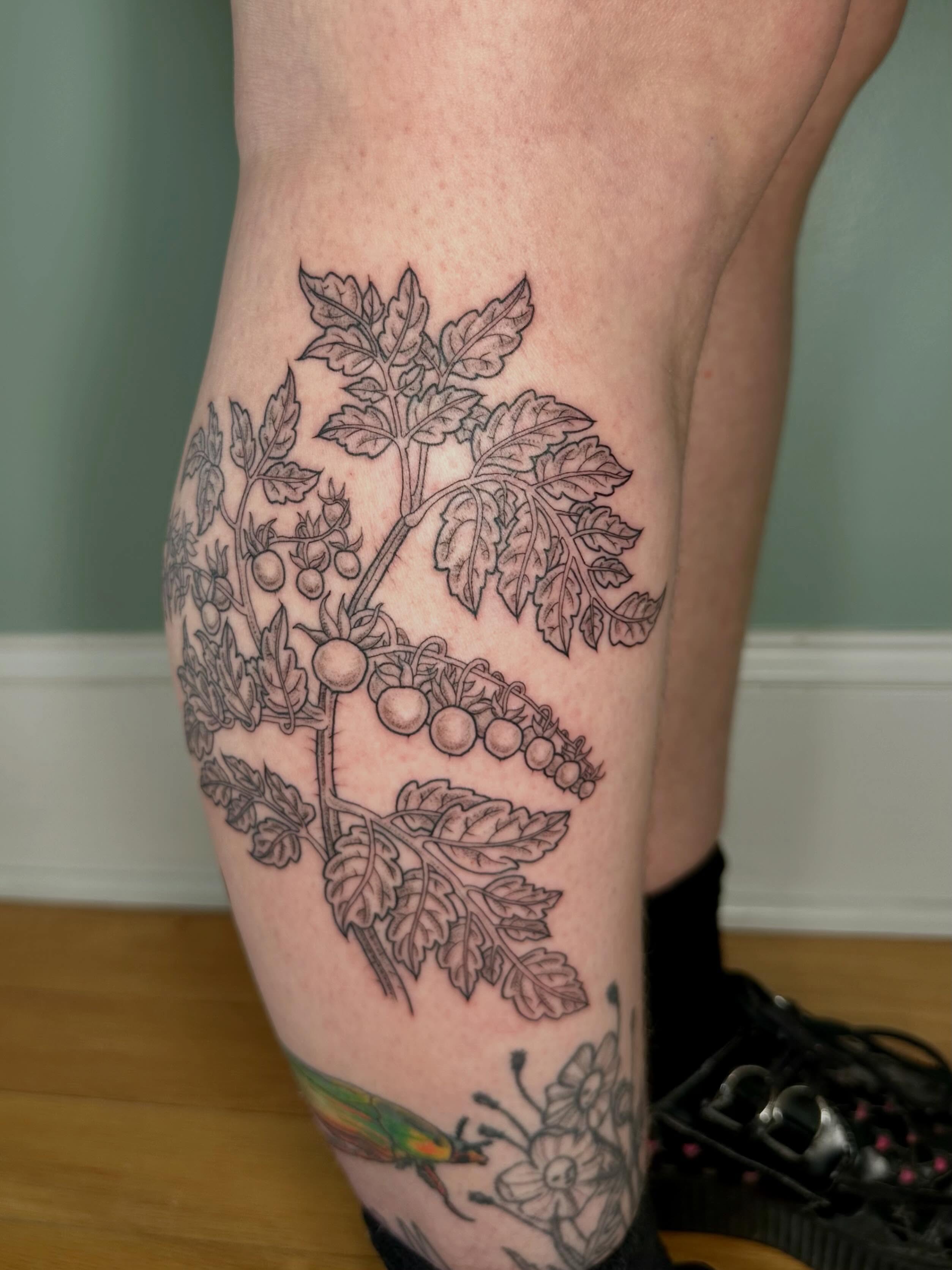 Berry plant black and grey tattoo on the thigh by Sarah Roach