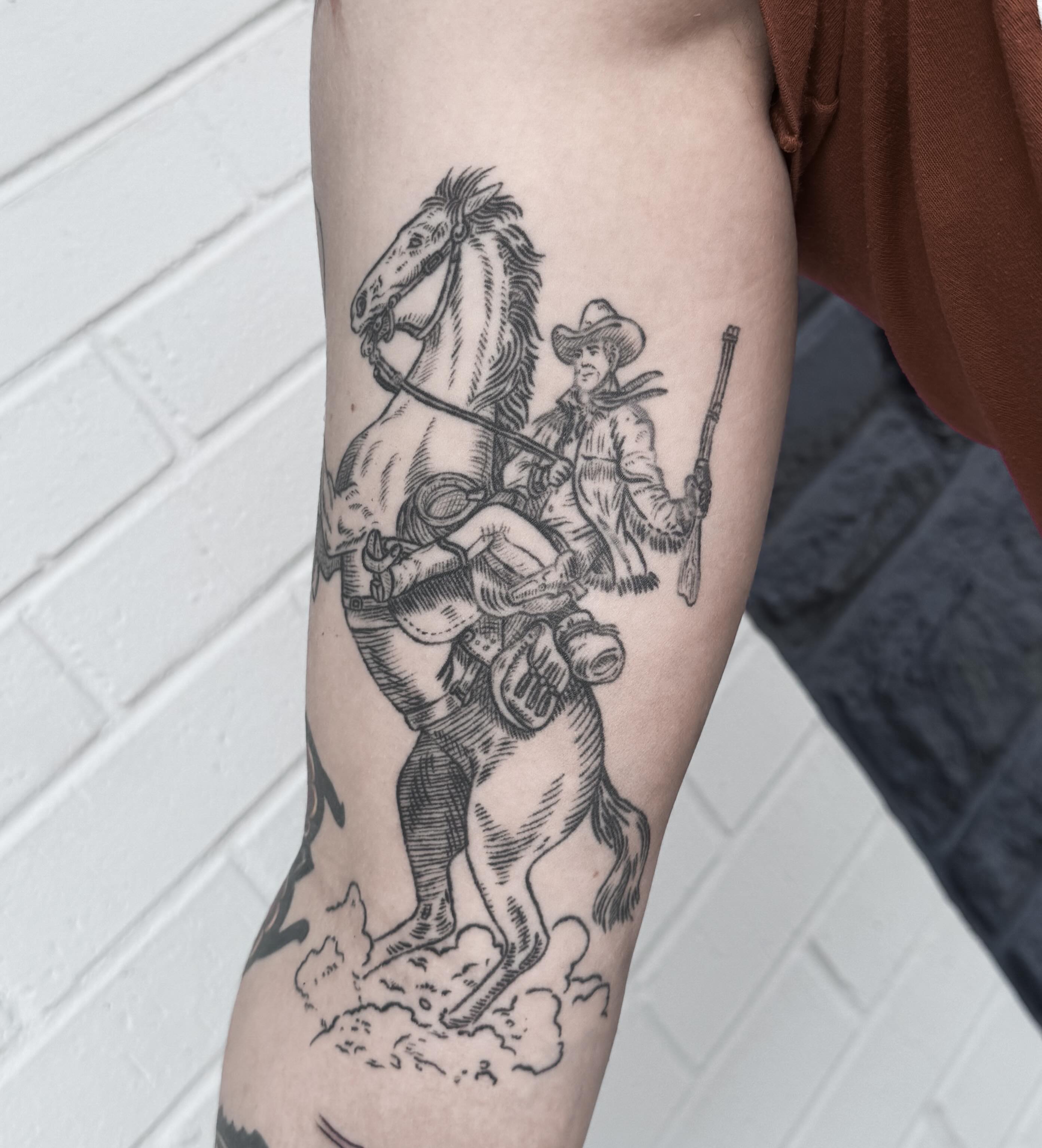 Cowboy on horse black and grey tattoo on the forearm by Audrey Kacel, Holland, Michigan