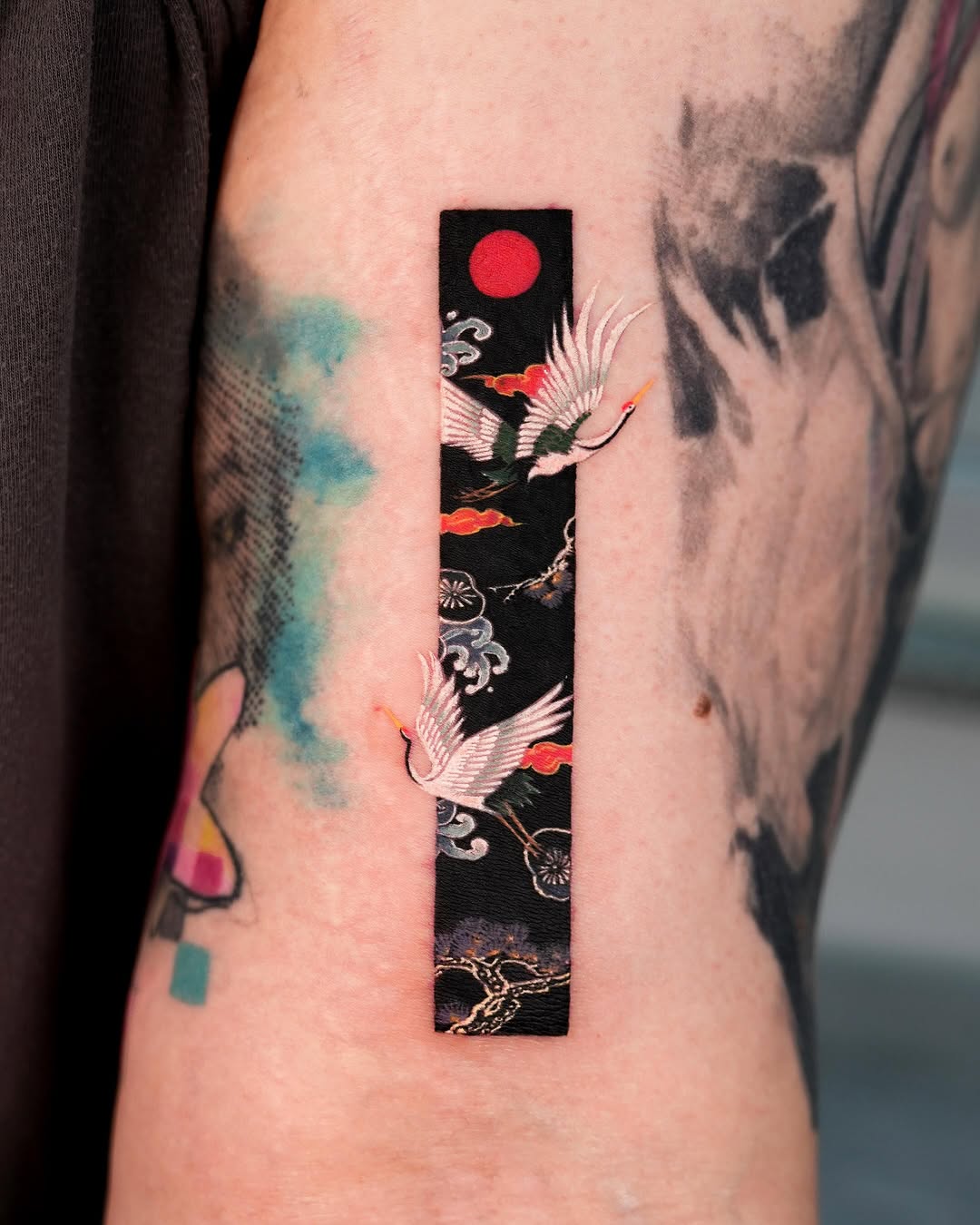 Cranes and red sun watercolor tattoo on the forearm by EQ