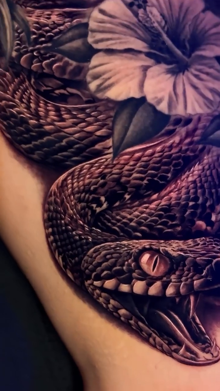 Snake and flowers realism tattoo on the upper arm by Raw Hound, Hialeah, Florida