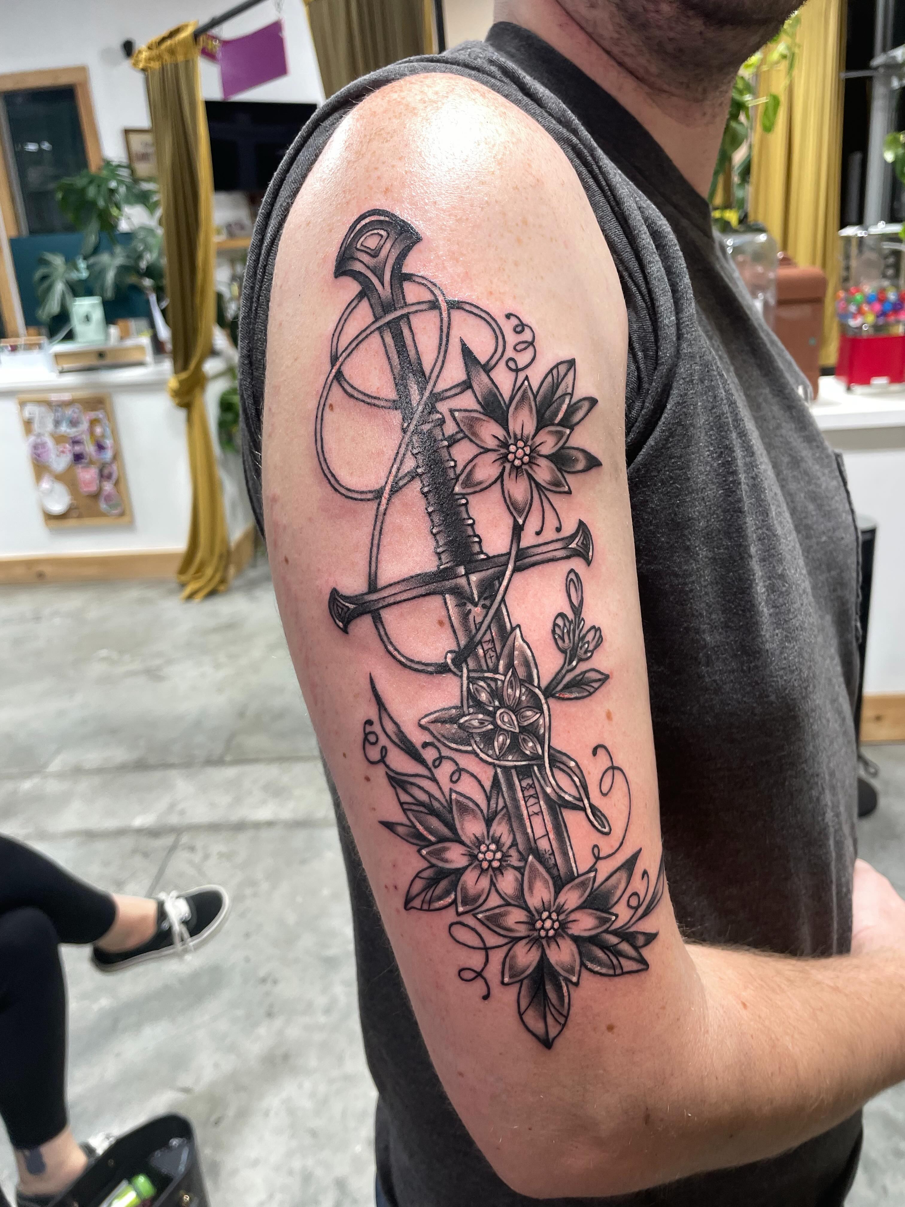 Sword and flowers black and grey tattoo on the forearm by Eric (EK) Kuldell