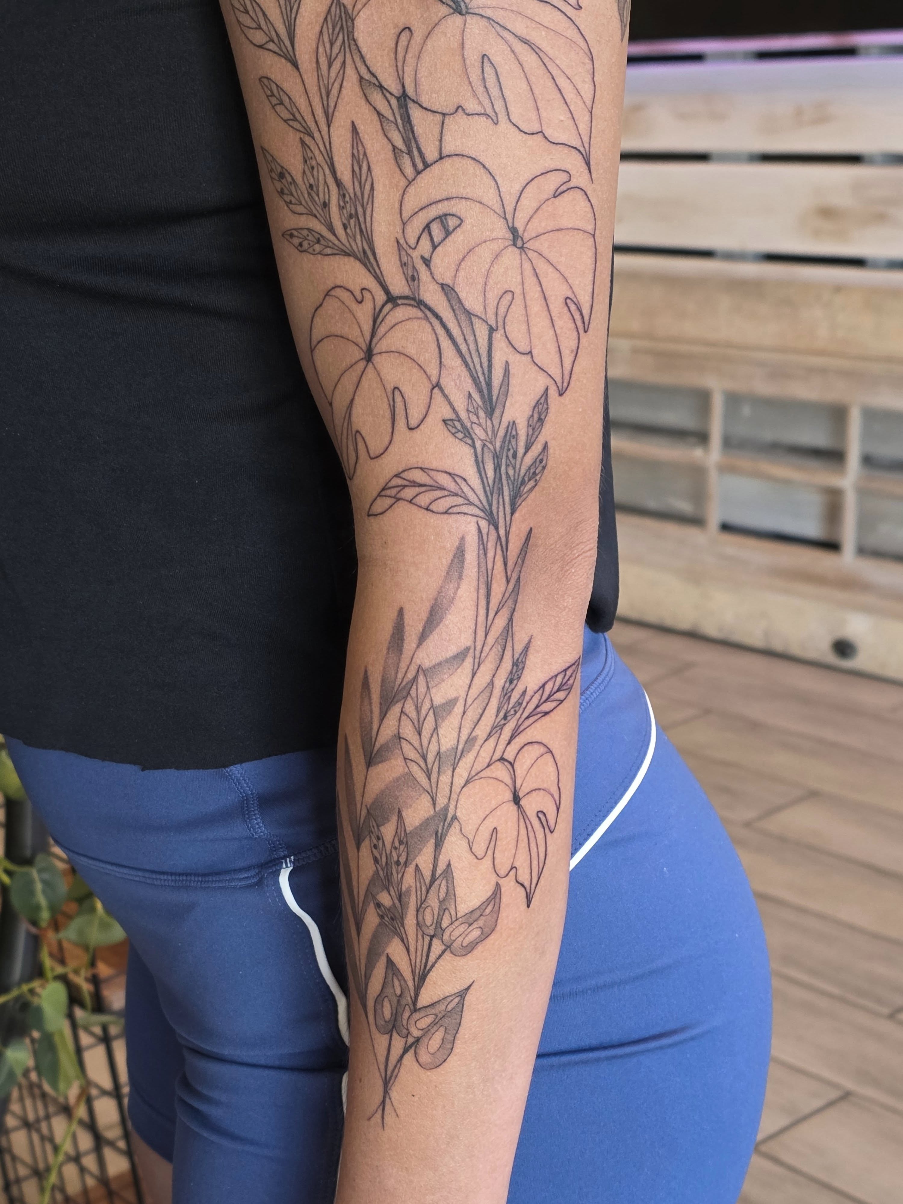 Floral arrangement black and grey tattoo on the forearm by Casey Jo