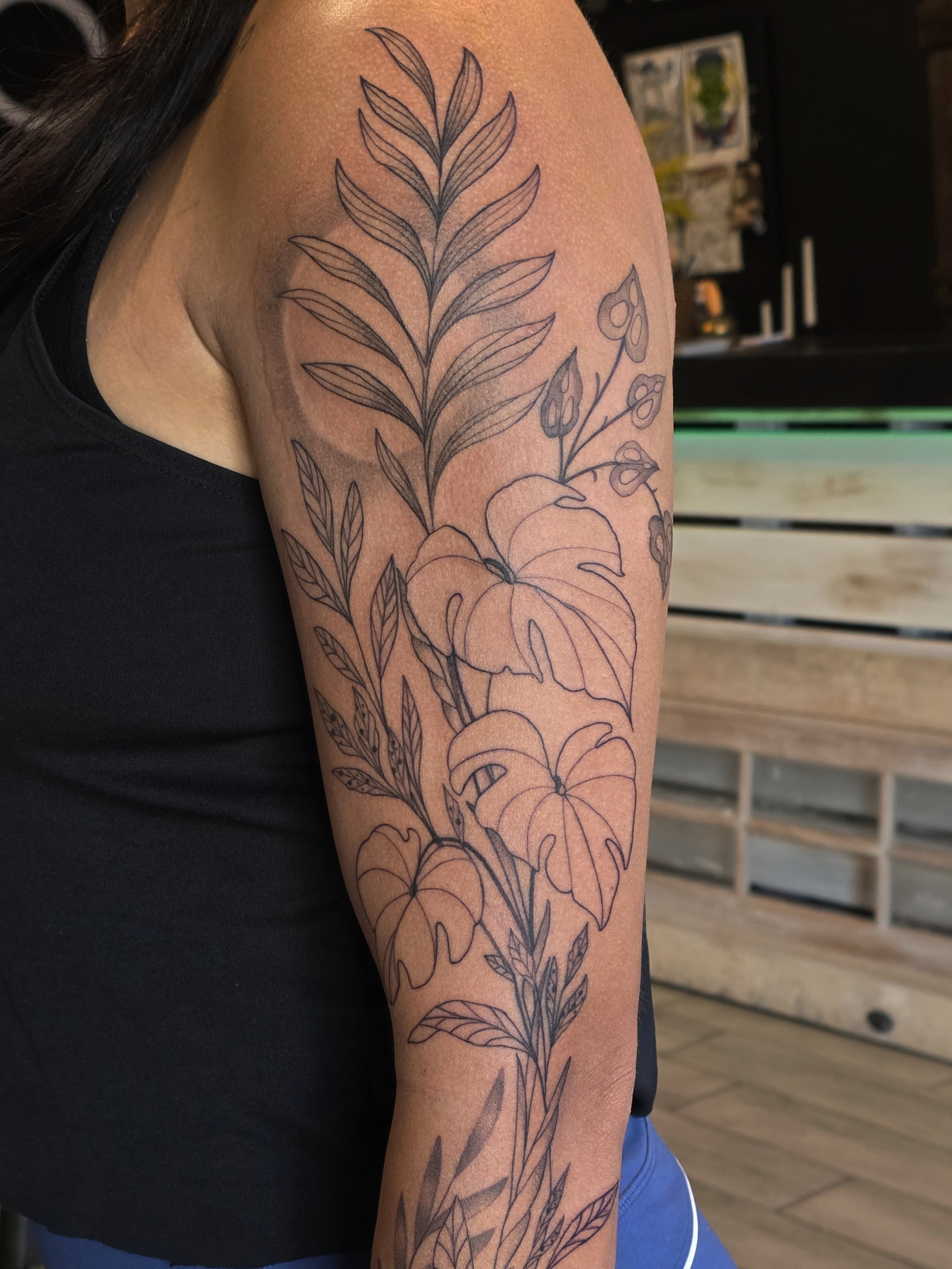Floral arrangement black and grey tattoo on the upper arm by Casey Jo