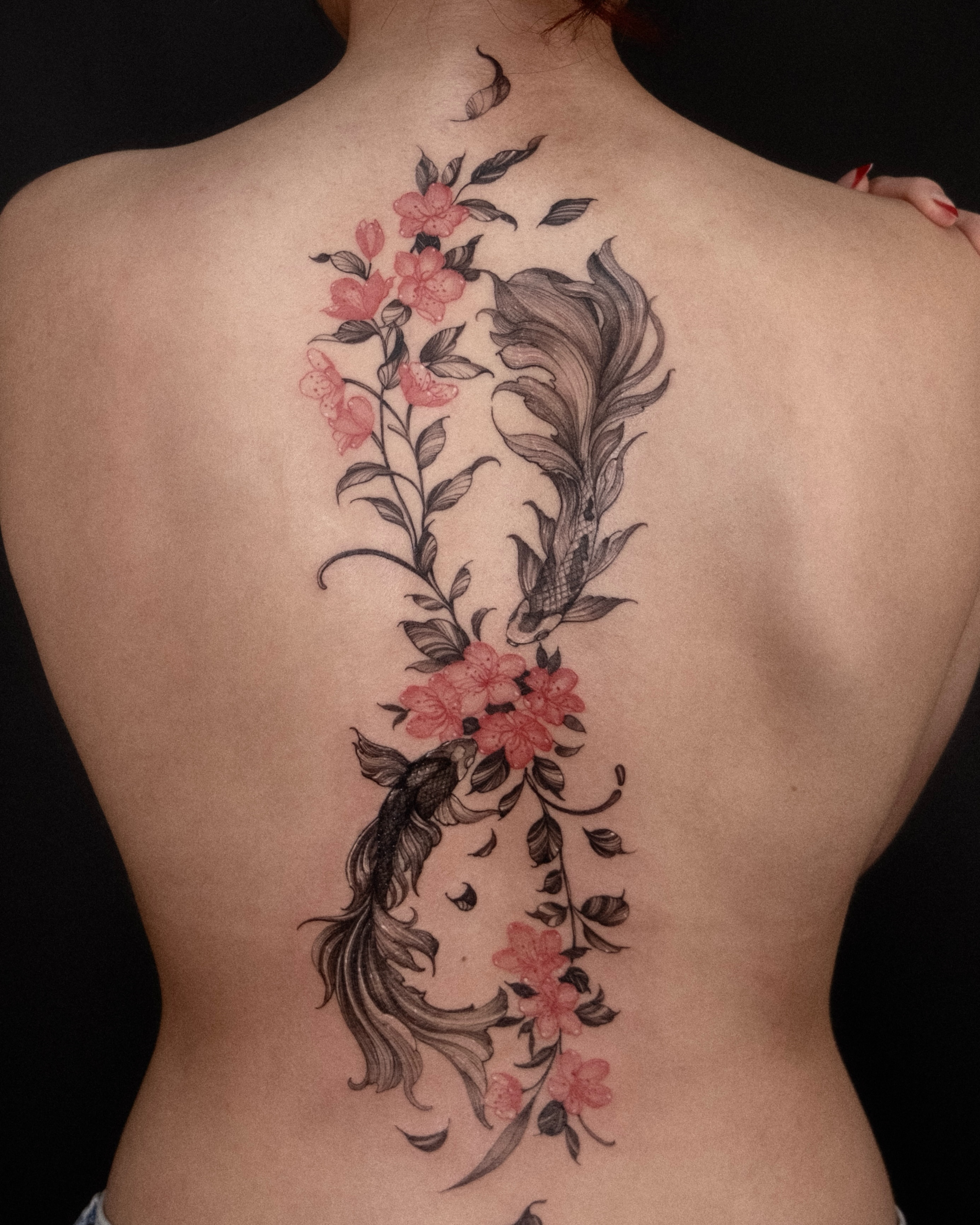 Flower and feather black and grey tattoo on the back by Wong Lee