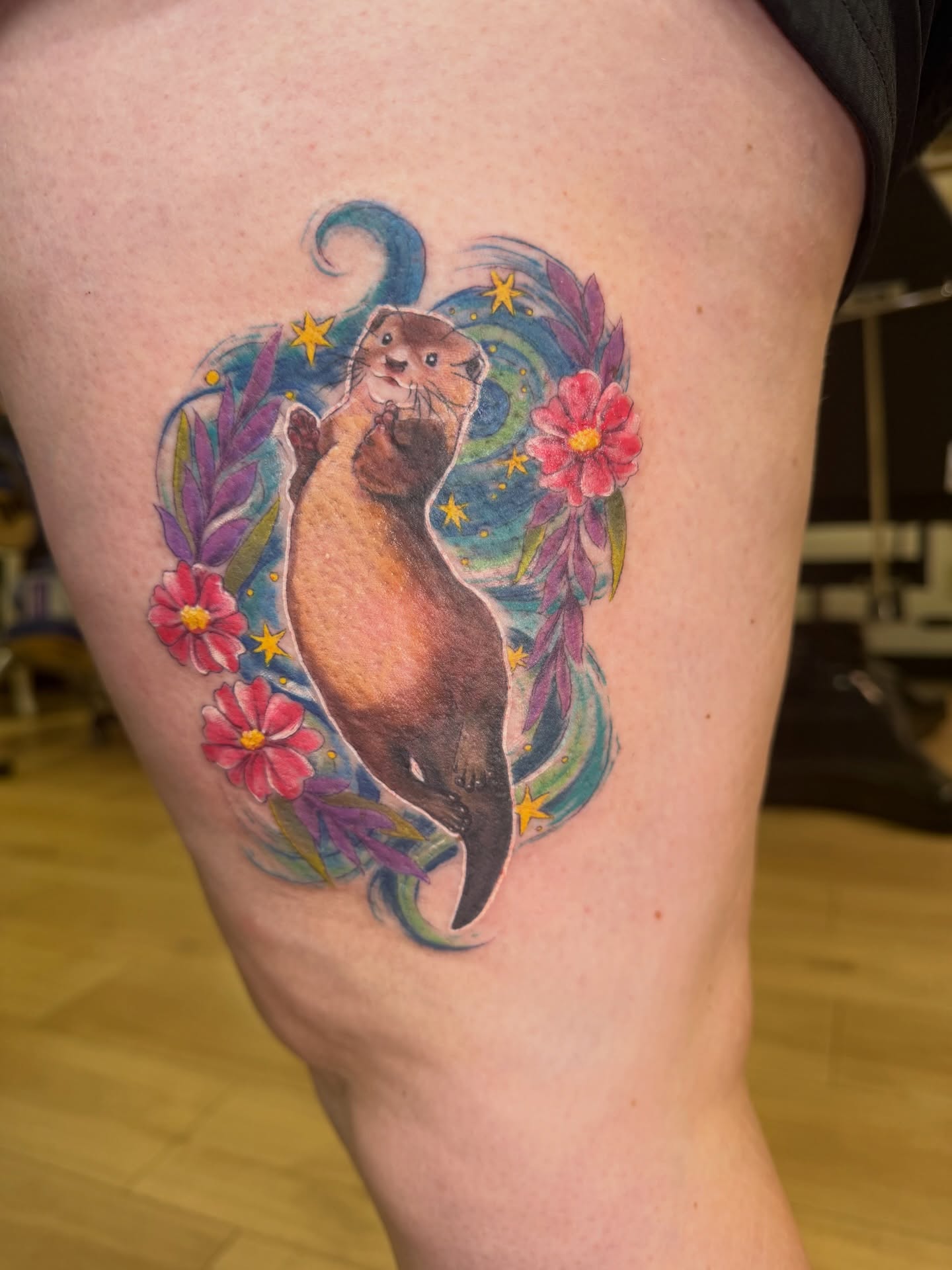 Otter watercolor tattoo on the thigh by Dani Fried Tattoos