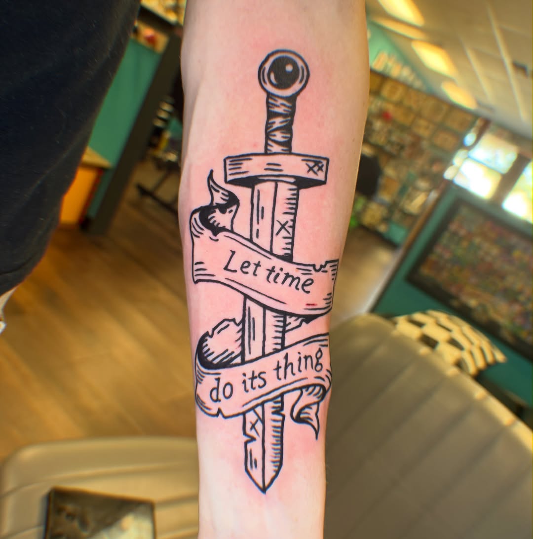Sword and banner black and grey tattoo on the forearm by π Erin Stephens π€
