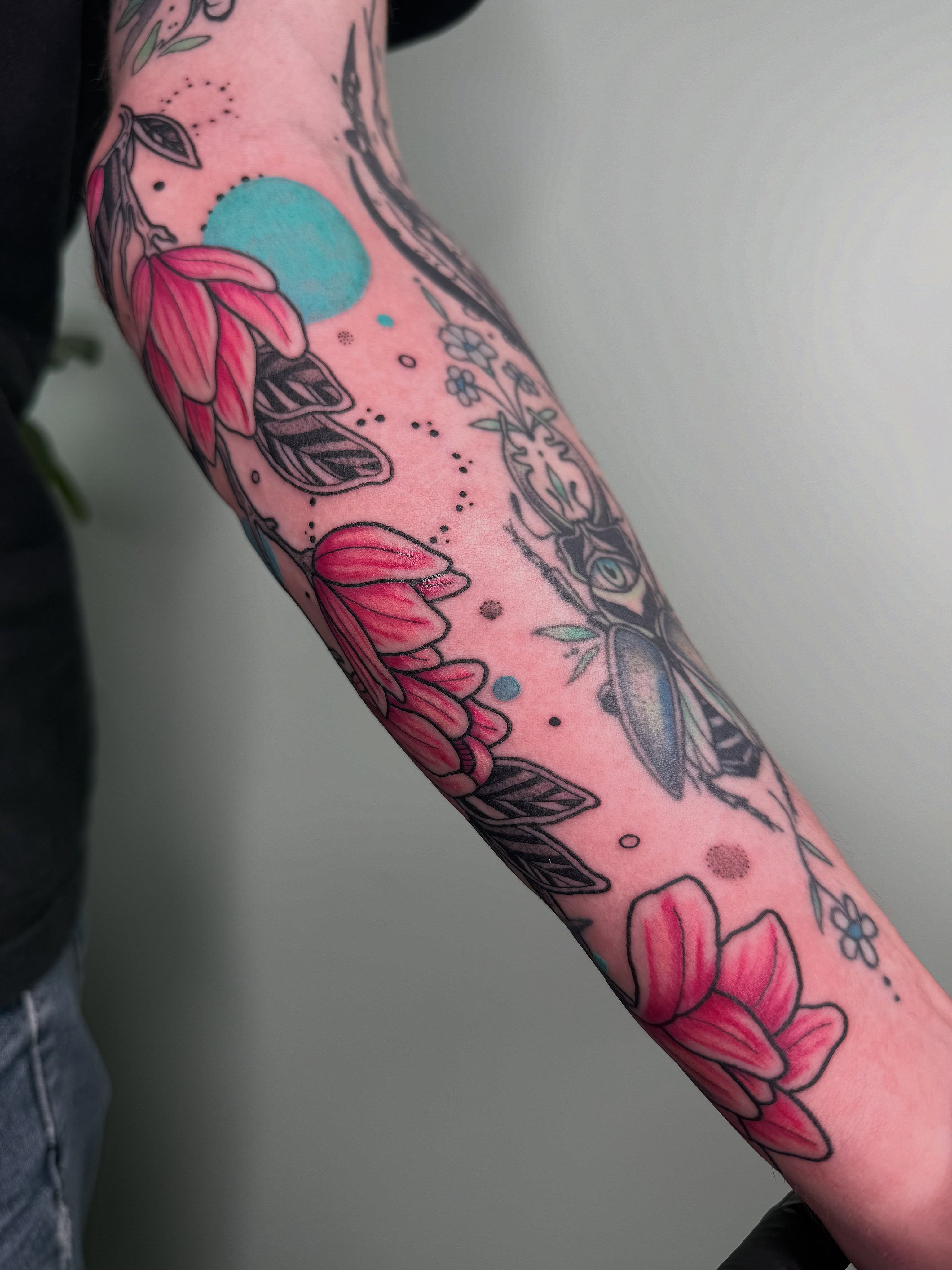 Flowers and deer American traditional tattoo on the forearm by AJ Jensen