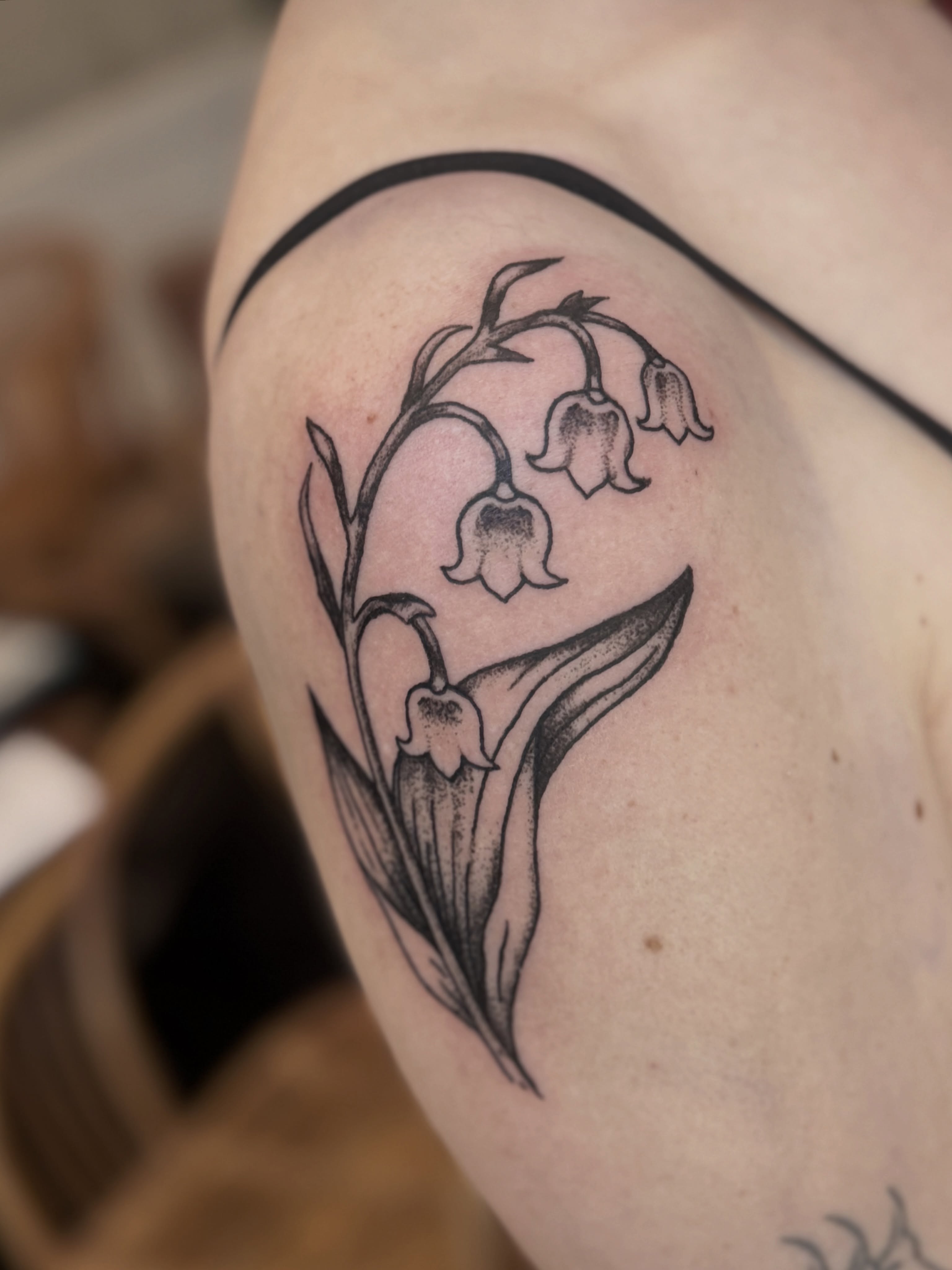 Lily of the valley black and grey tattoo on the upper arm by Tattoo Artist, Philadelphia, Pennsylvania