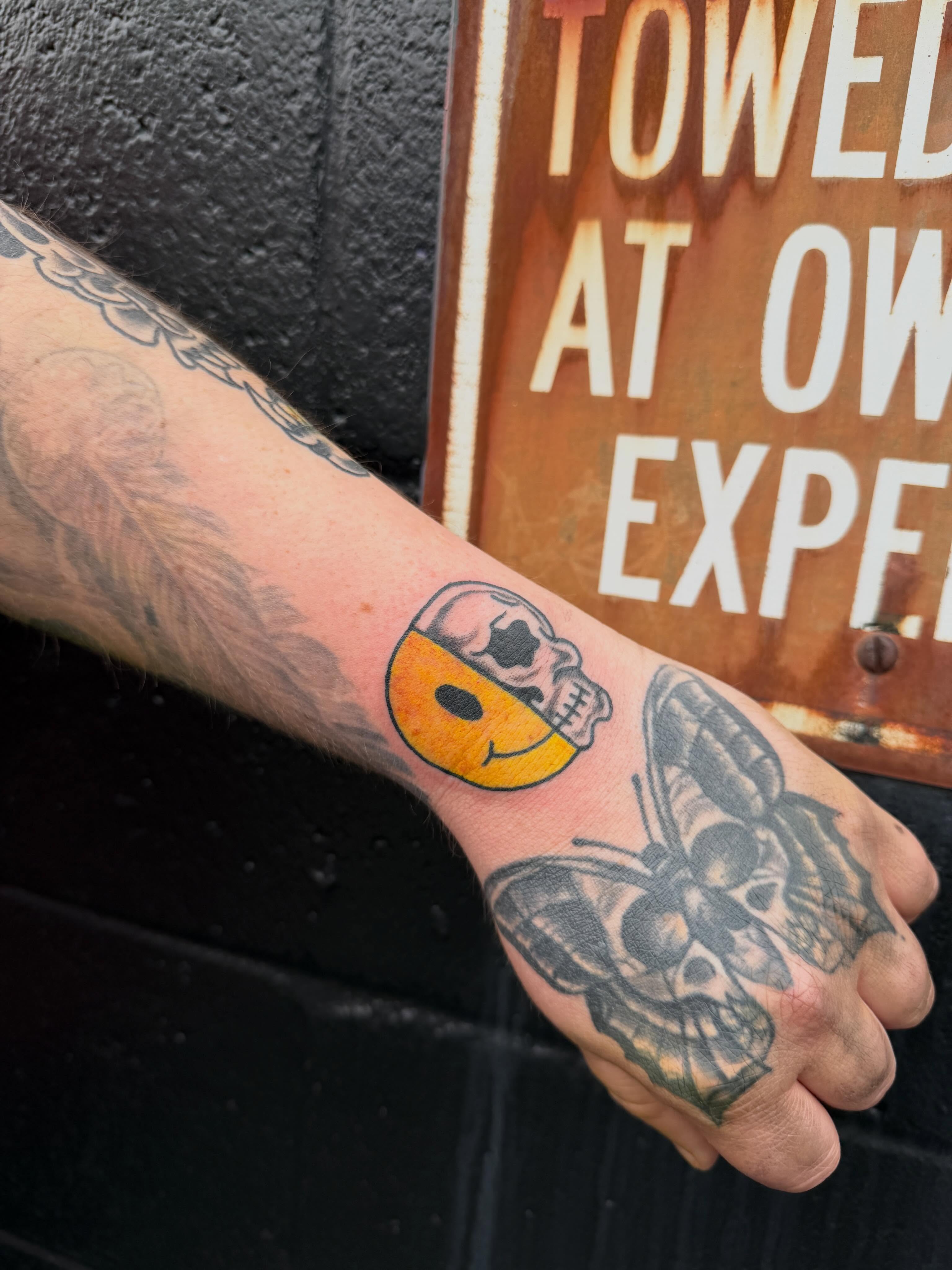 Skull and donut American traditional tattoo on the forearm by Ali Calis