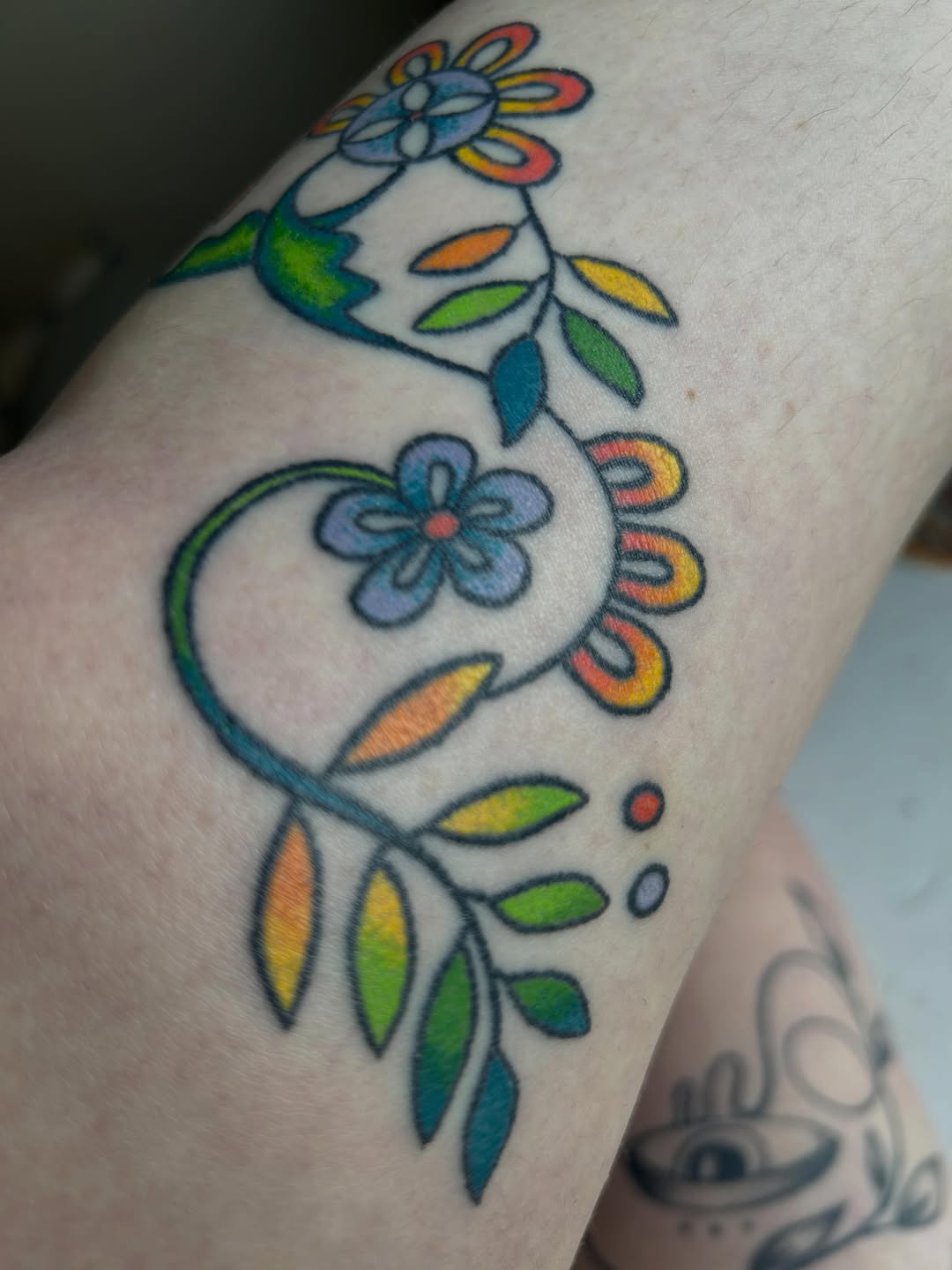 Floral vine watercolor tattoo on the forearm by Emma D