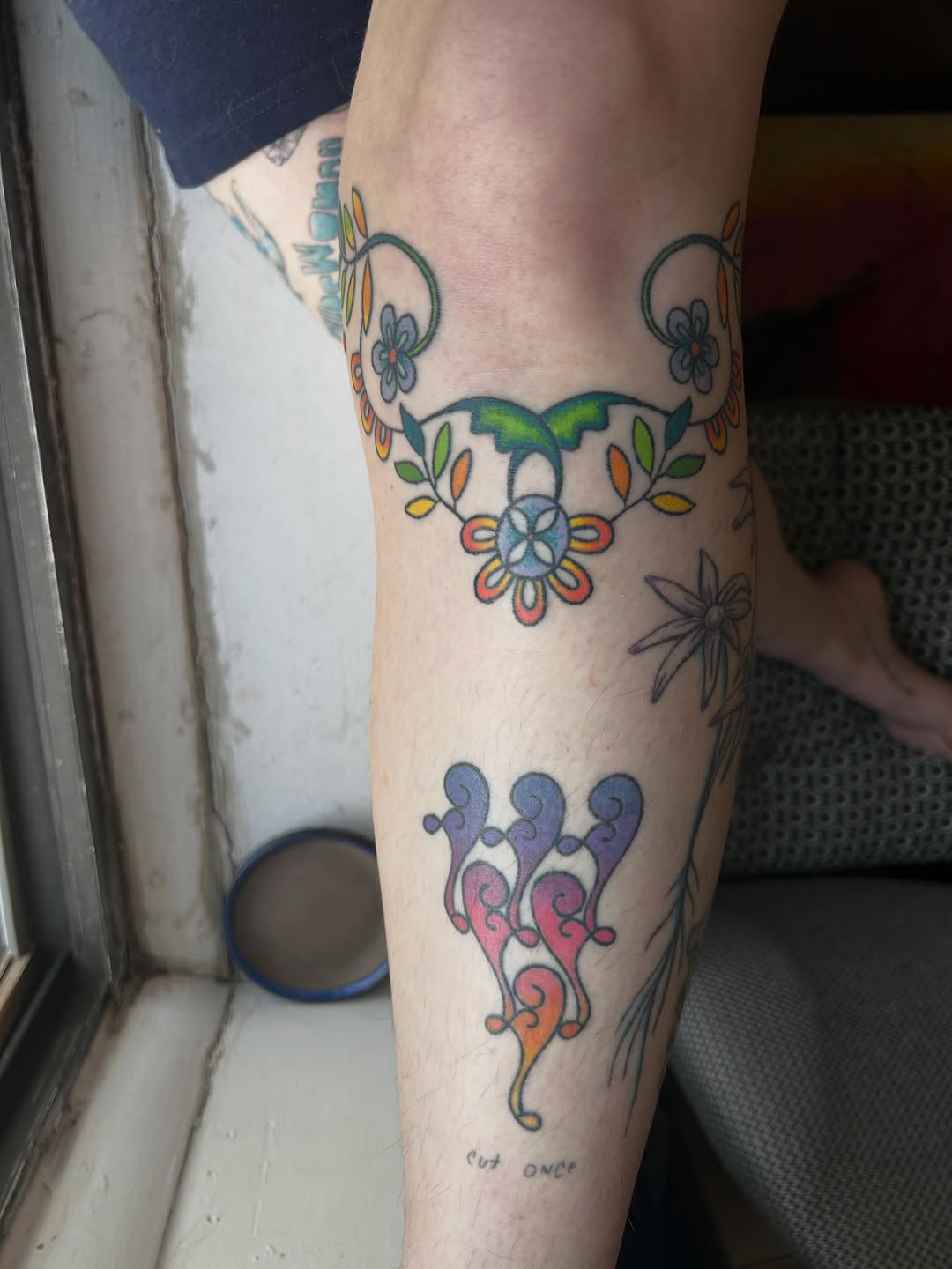 Floral vine and abstract shapes tattoo on the forearm by Emma D
