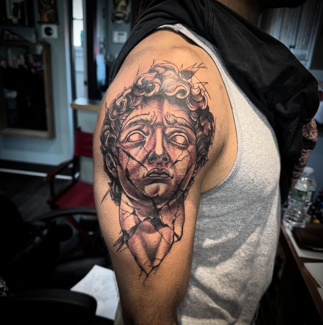 Cracked bust realism tattoo on the shoulder by Cory Haberman