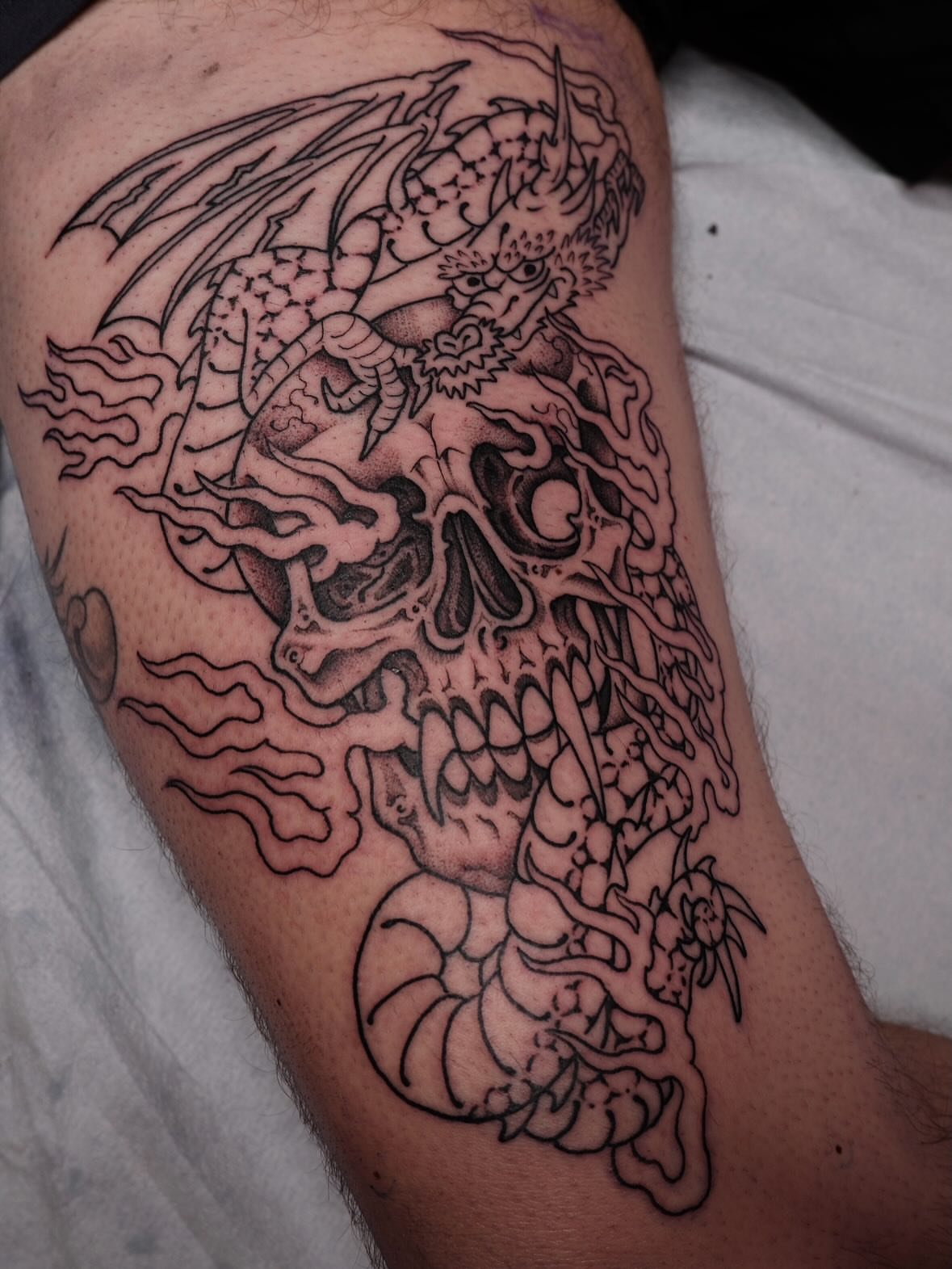 Skull and dragon realism tattoo on the thigh by B