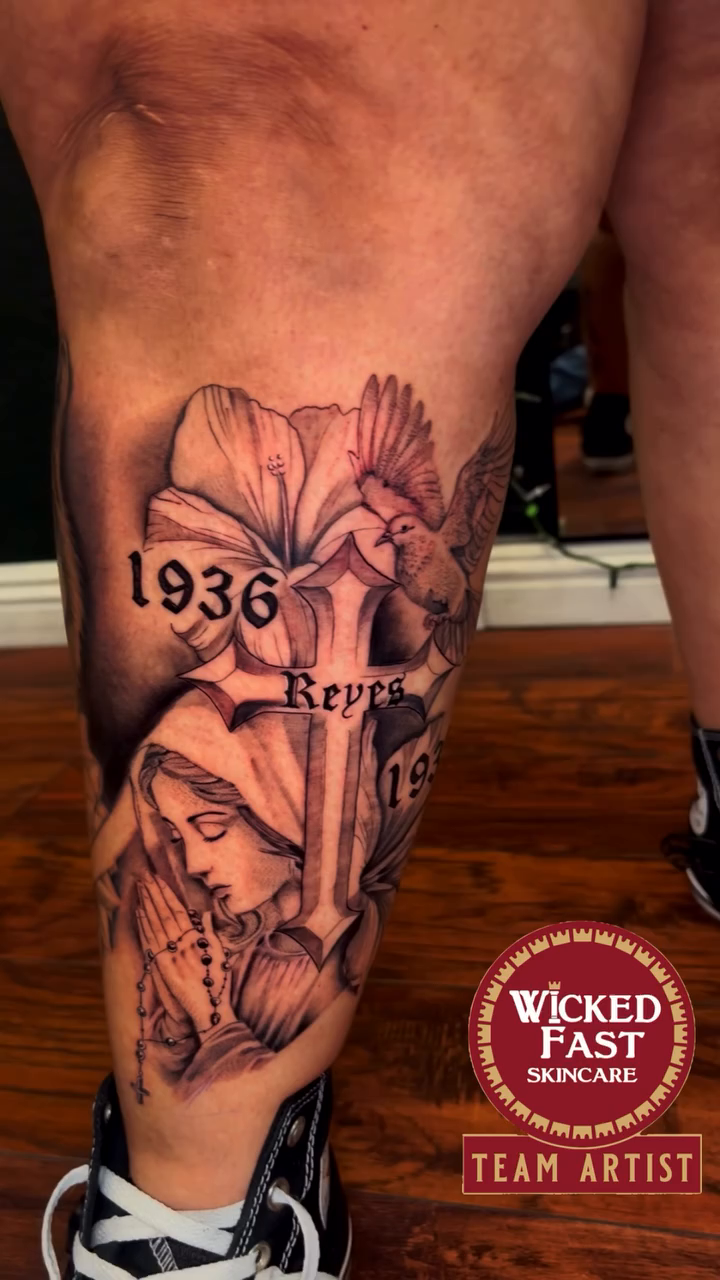 Virgin Mary, cross, dates, and flowers realism tattoo by Cultura