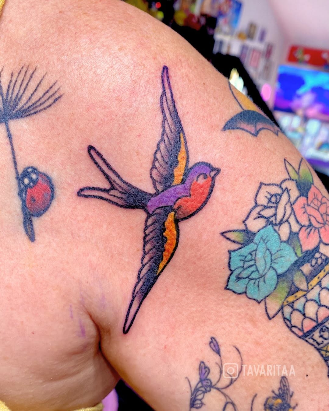 Colorful flying bird tattoo on the shoulder by Tavarita