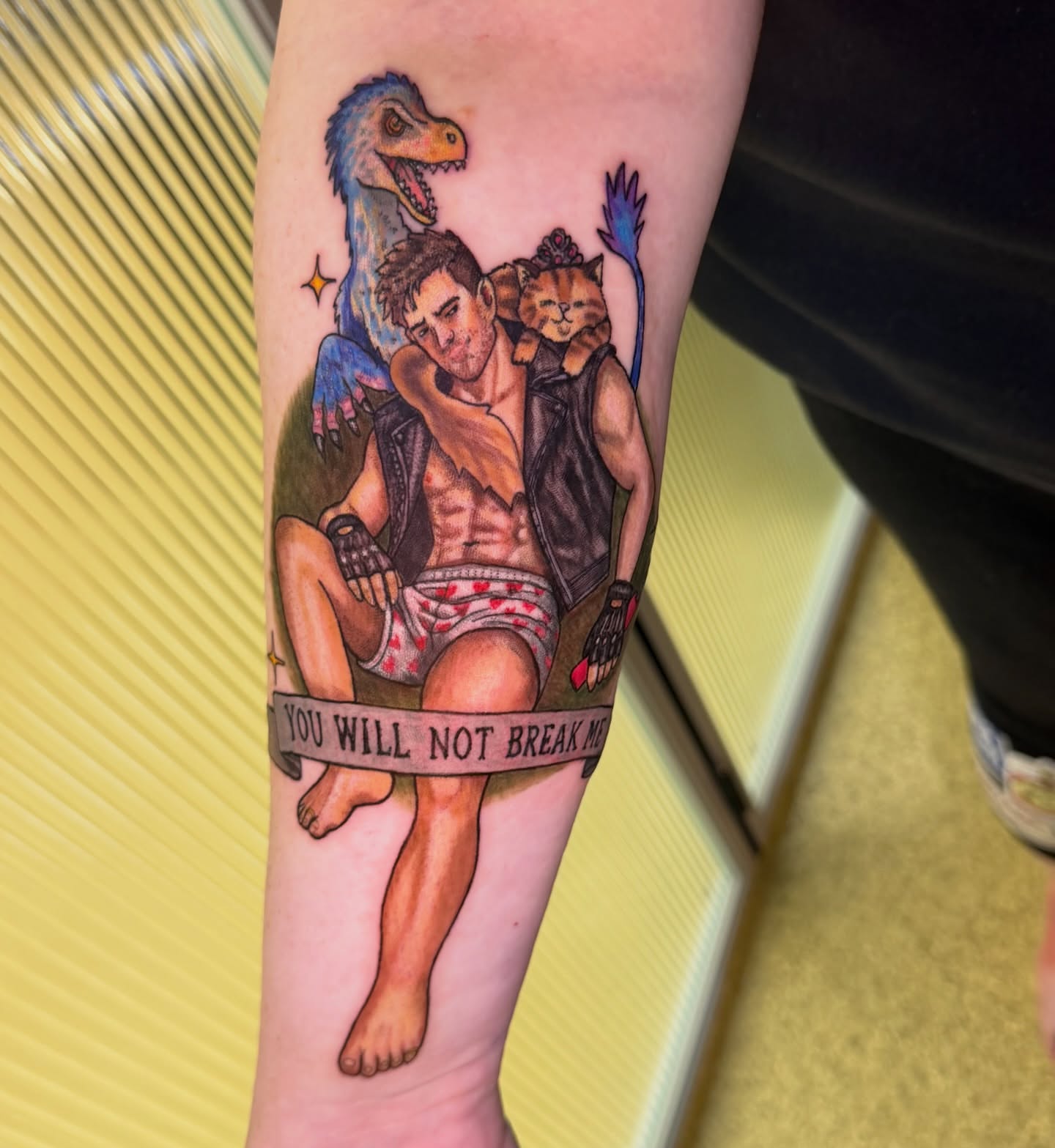 Man with dinosaur and cat realism tattoo on the forearm by Abbie Kaitlynn Taylor, Dayton, Ohio