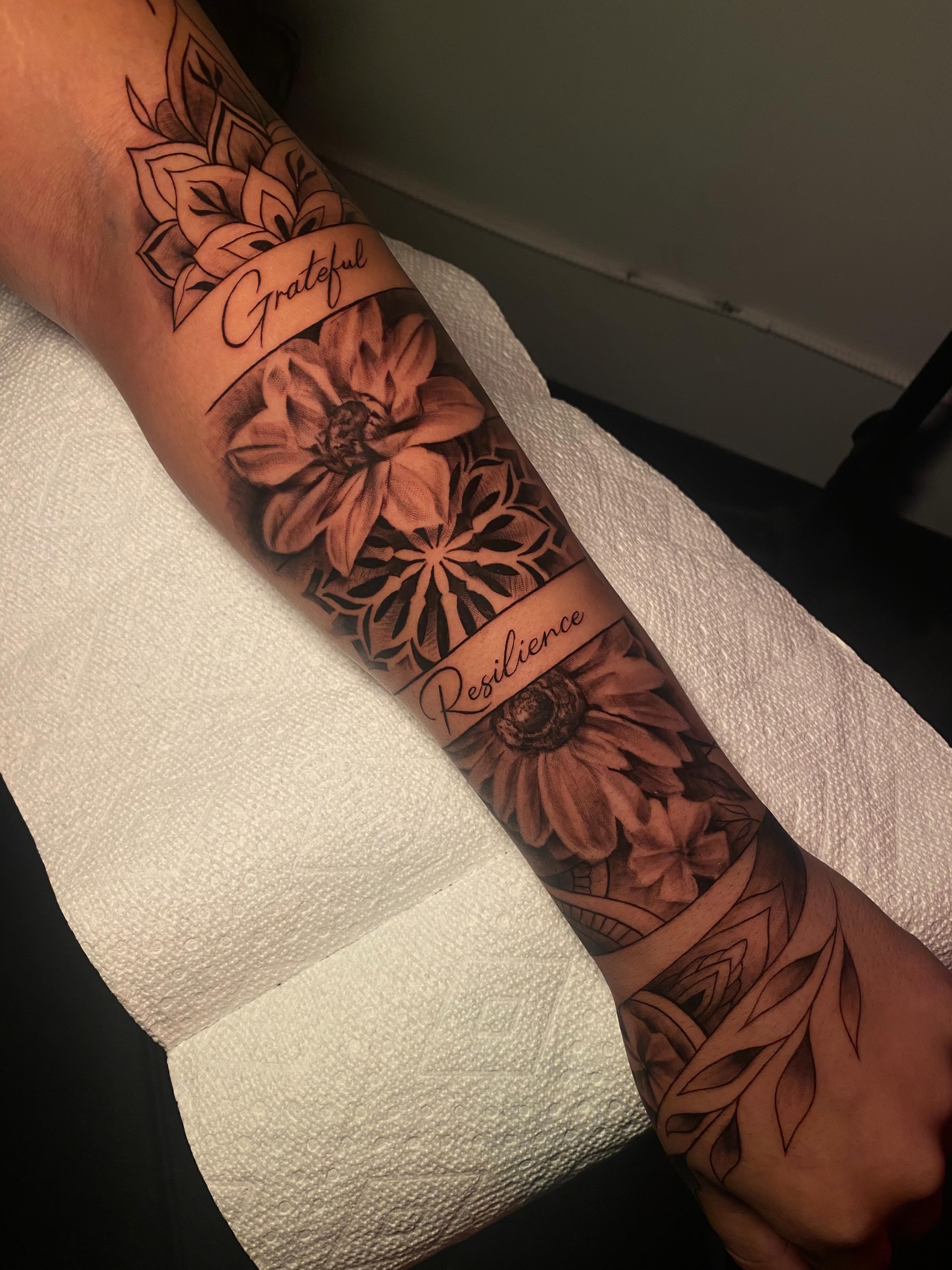 Sunflowers and floral patterns realism tattoo on the forearm by Tattoo Artist