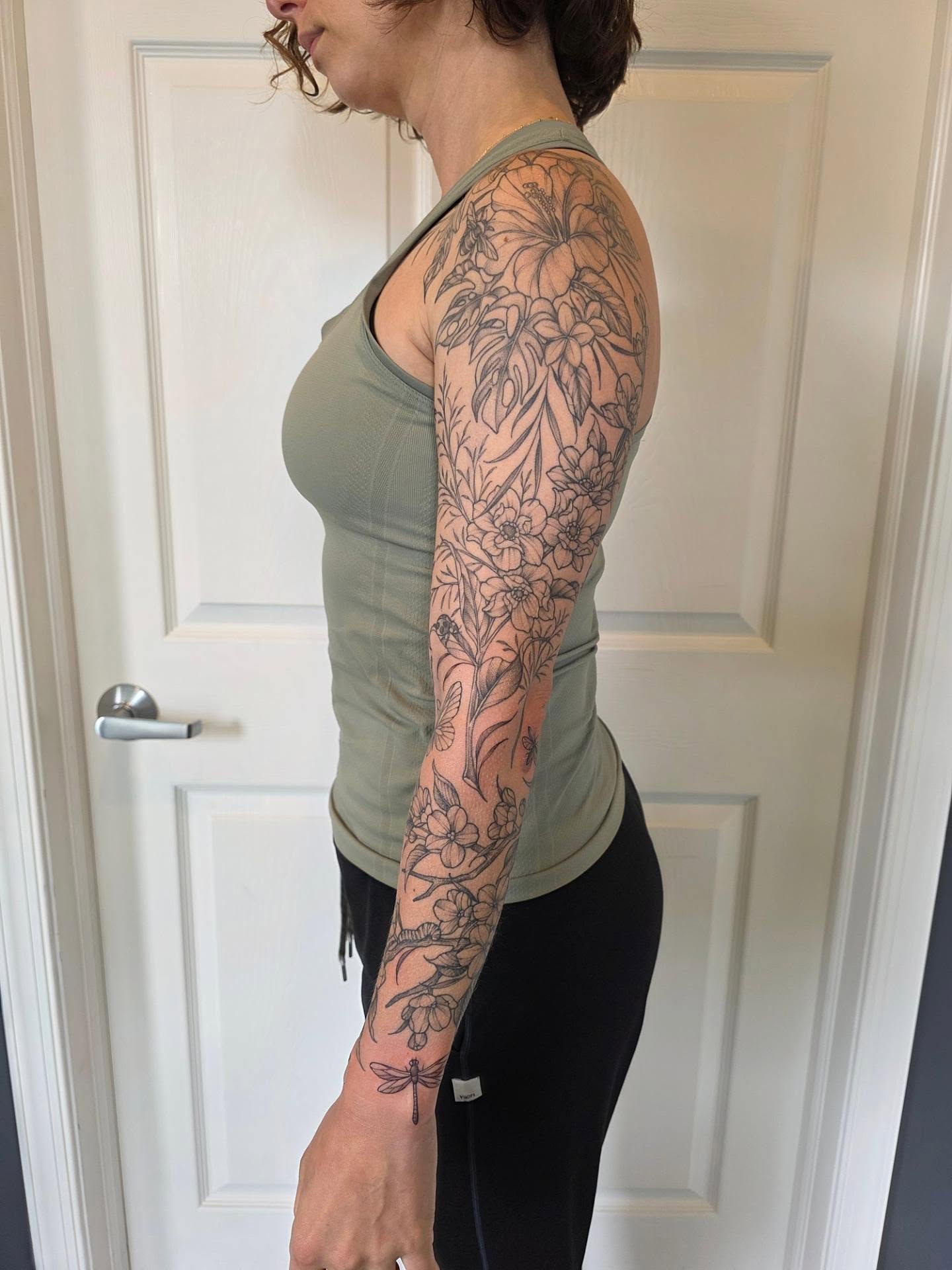 Floral black and grey tattoo on the upper arm by Dani Bond