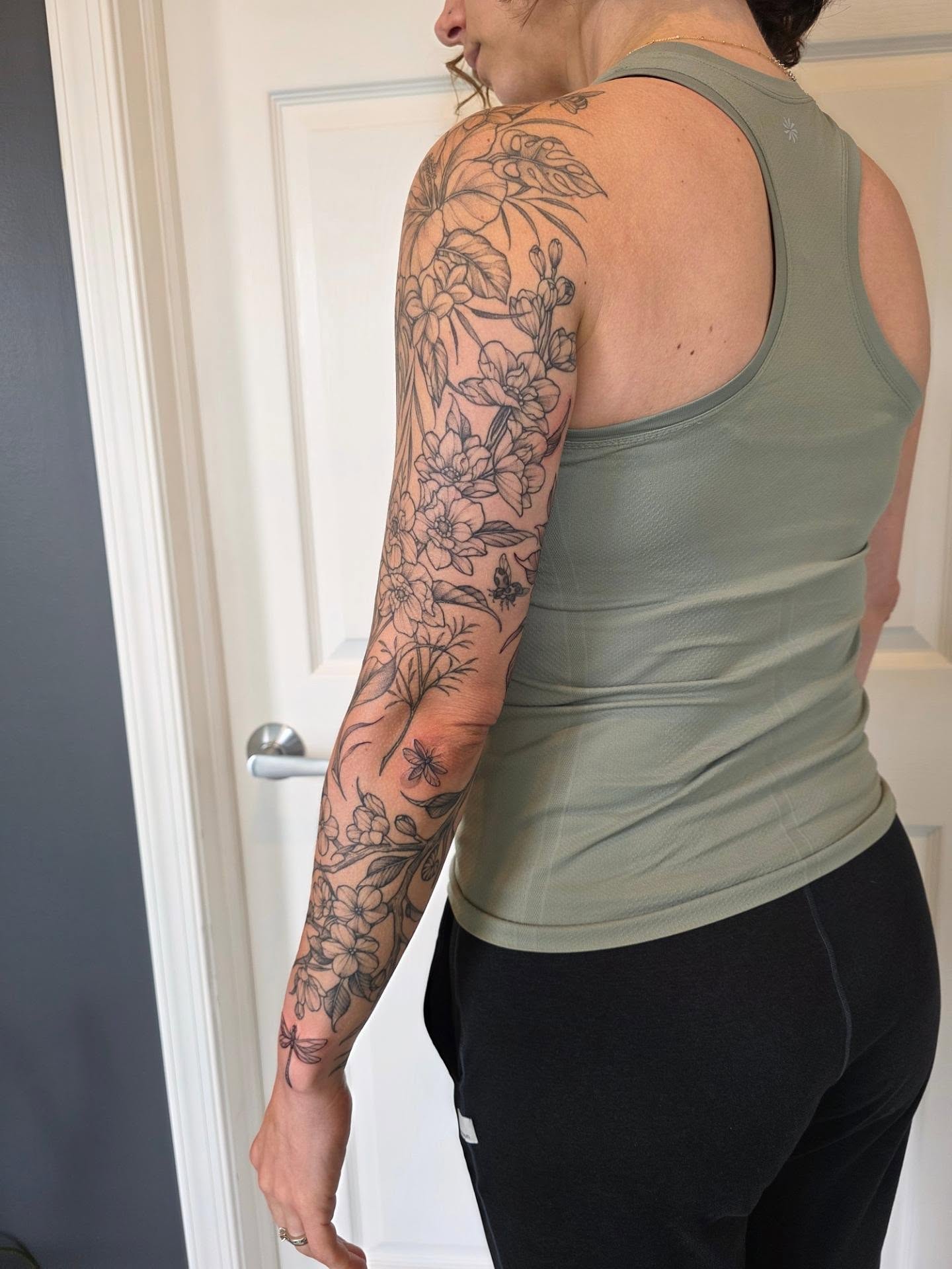 Floral arrangement black and grey tattoo on the upper arm by Dani Bond