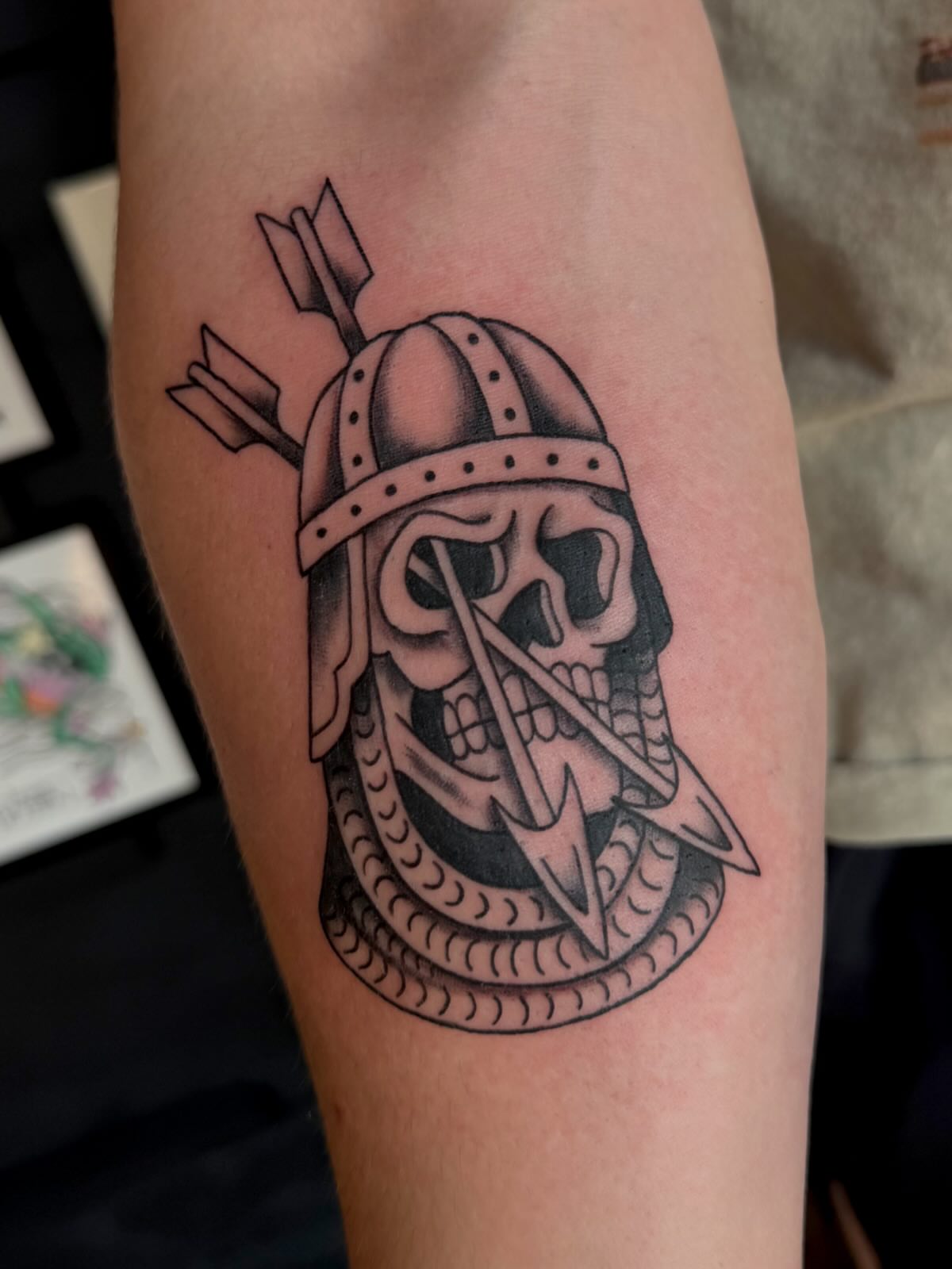 Skull helmet black and grey tattoo on the forearm by Alaska ⚜️