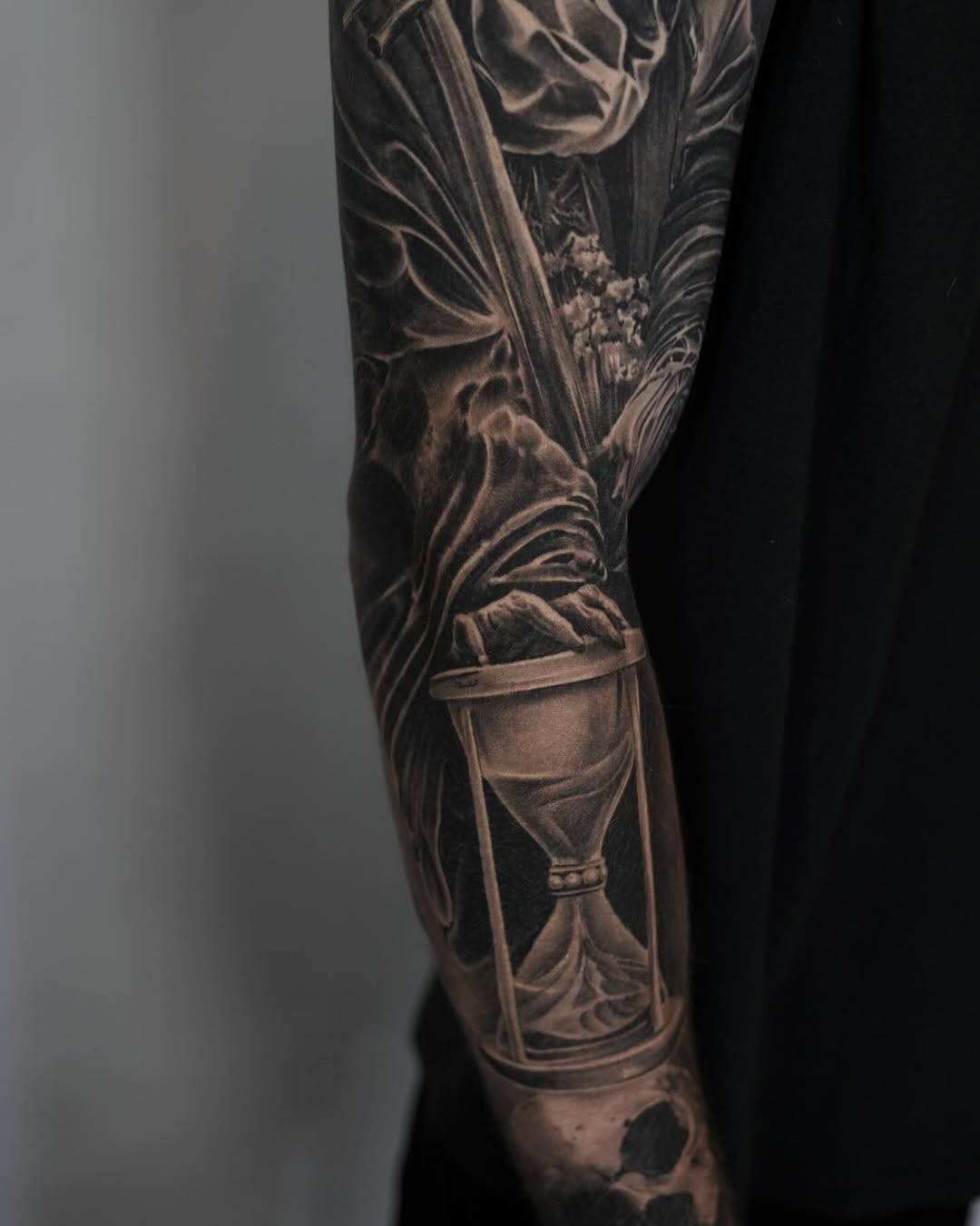 Hourglass and draped fabric realism tattoo on the forearm by Facundo Gil