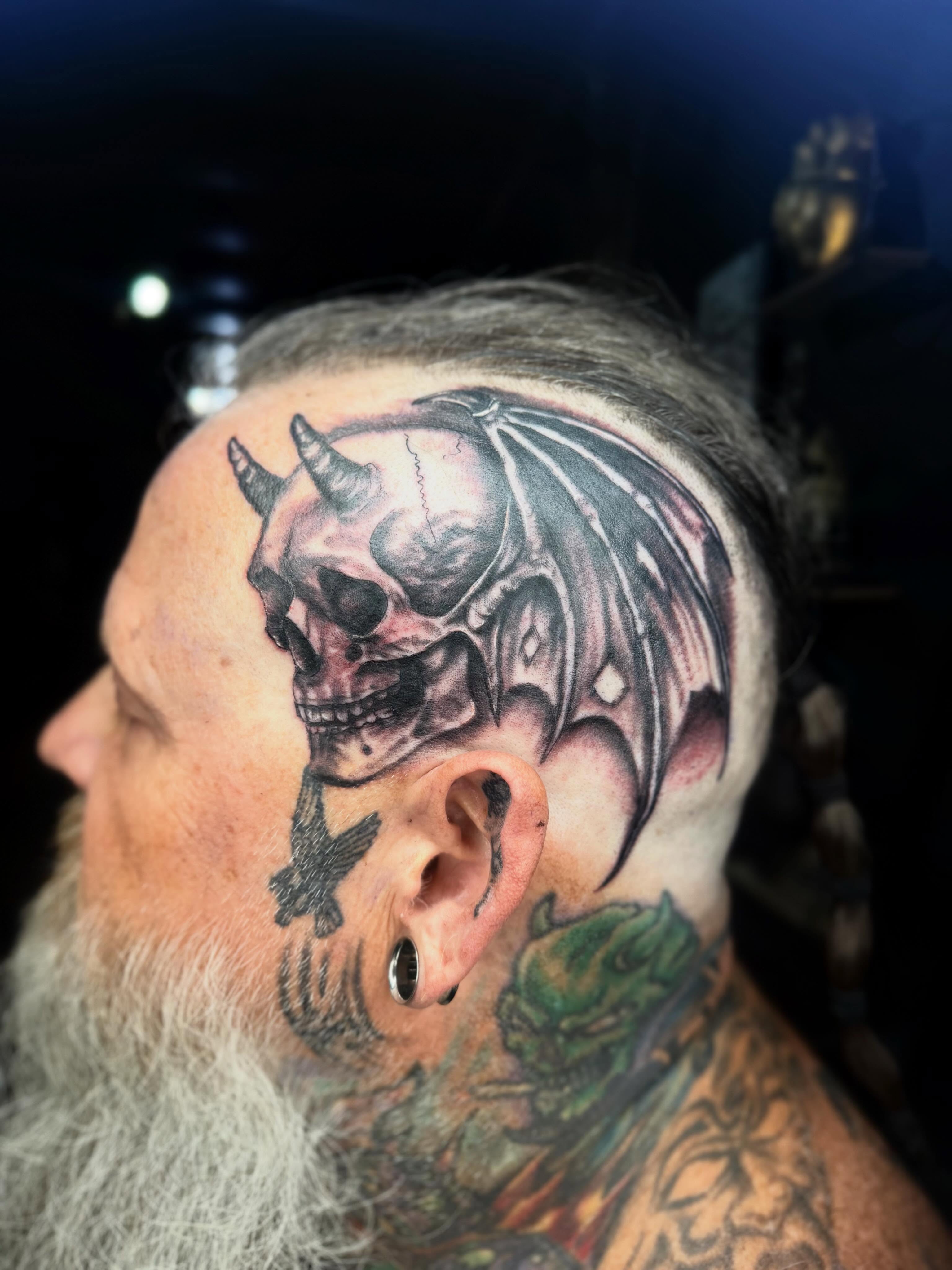 Skull with wings realism tattoo on the head by Teara faith krigbaum