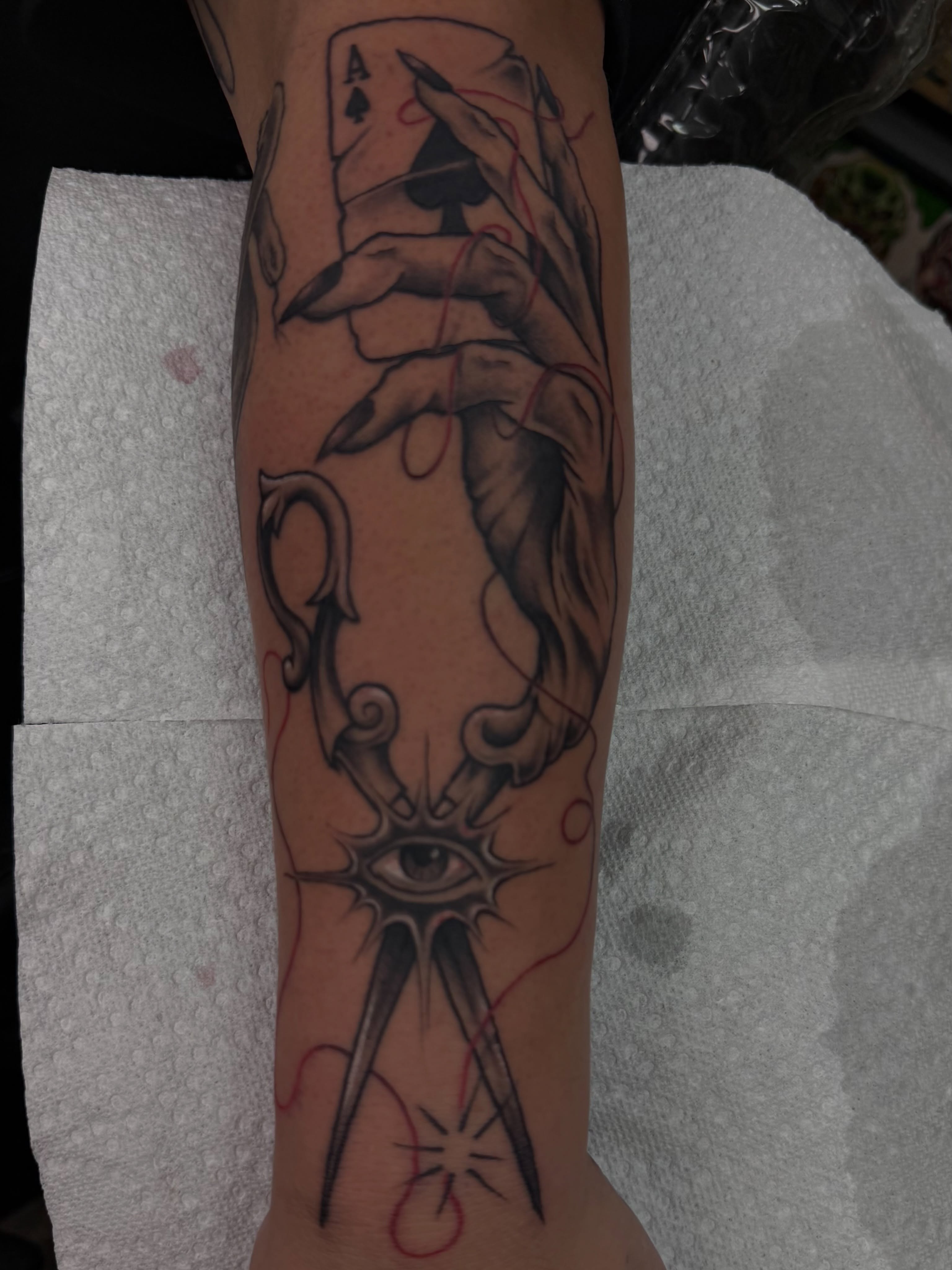 Hand holding ace card realism tattoo on the forearm by Josh Kronauer