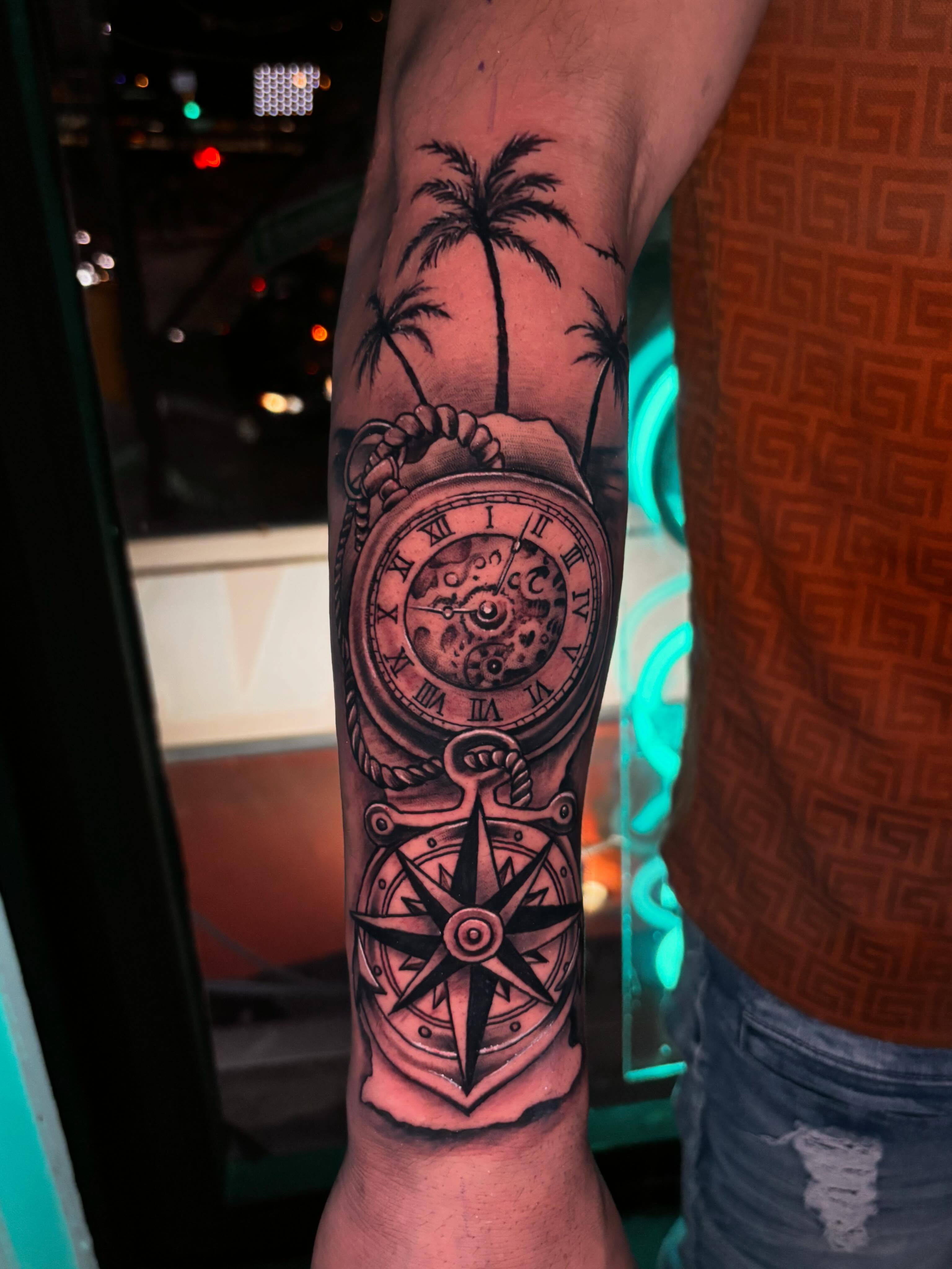 Palm tree, pocket watch, compass black and grey tattoo on the forearm by Daero Tattoo, New York, New York