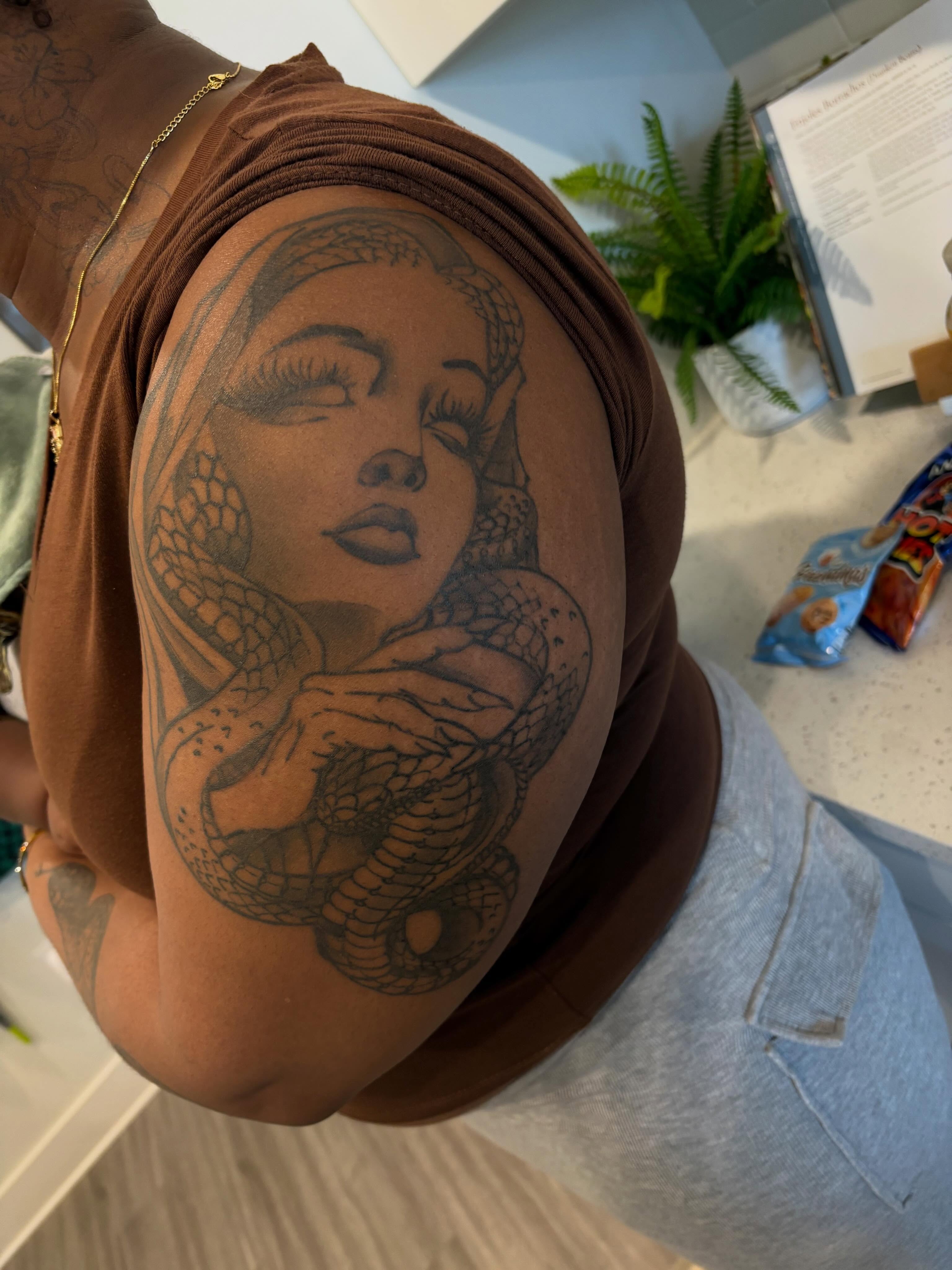 Woman with snake realism tattoo on the shoulder by Picasso Ken💫