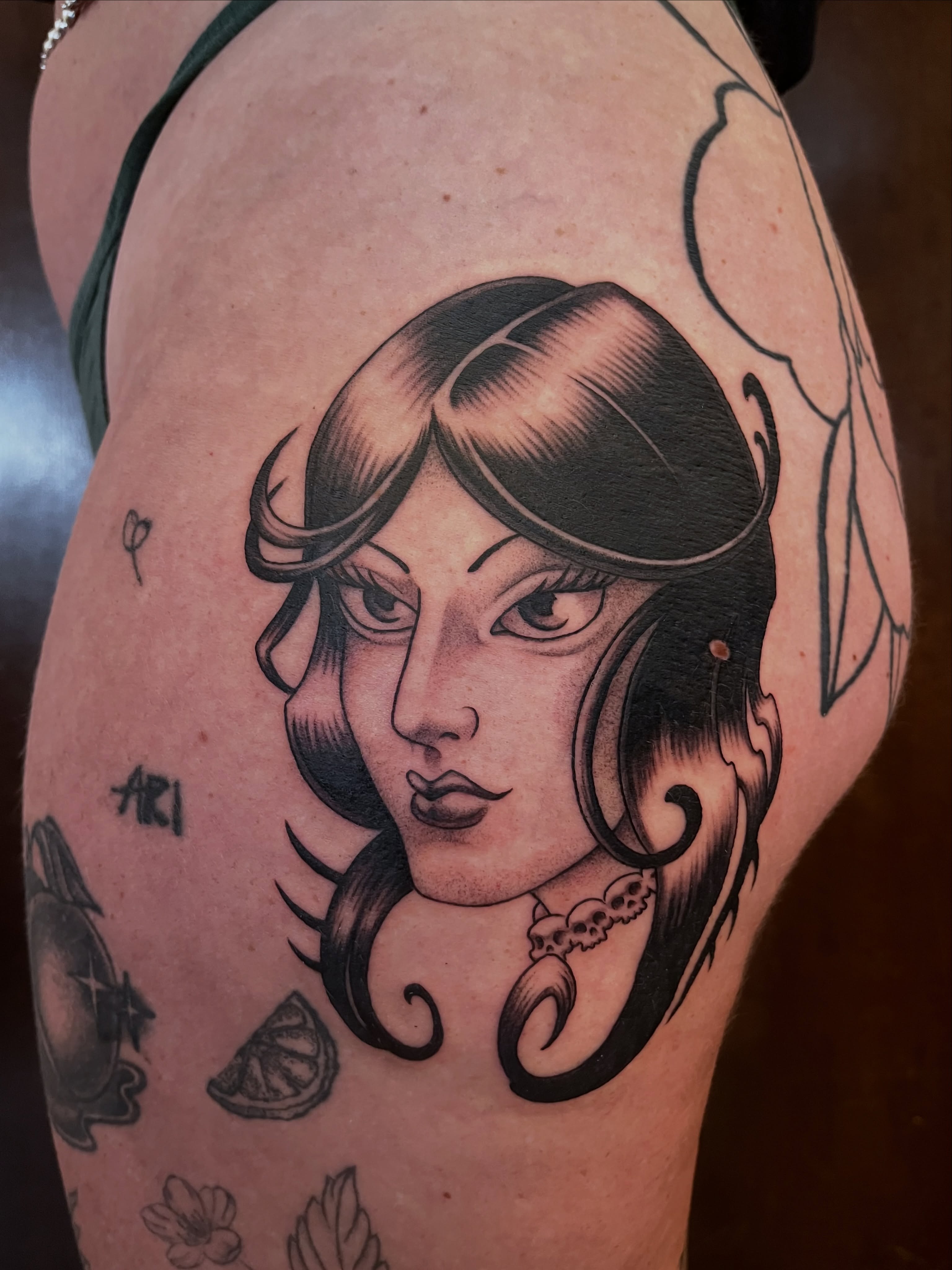 Woman's face American traditional tattoo on the thigh by Campbell Zane Alexander
