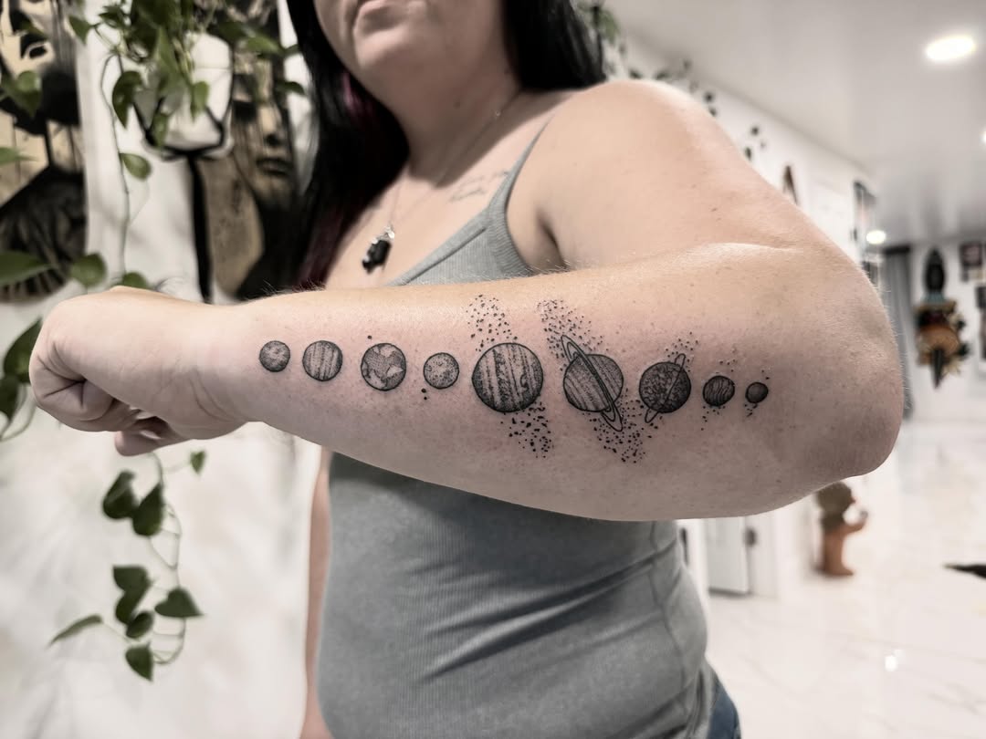 Planetary system dotwork tattoo on the forearm by Shannon Misitano