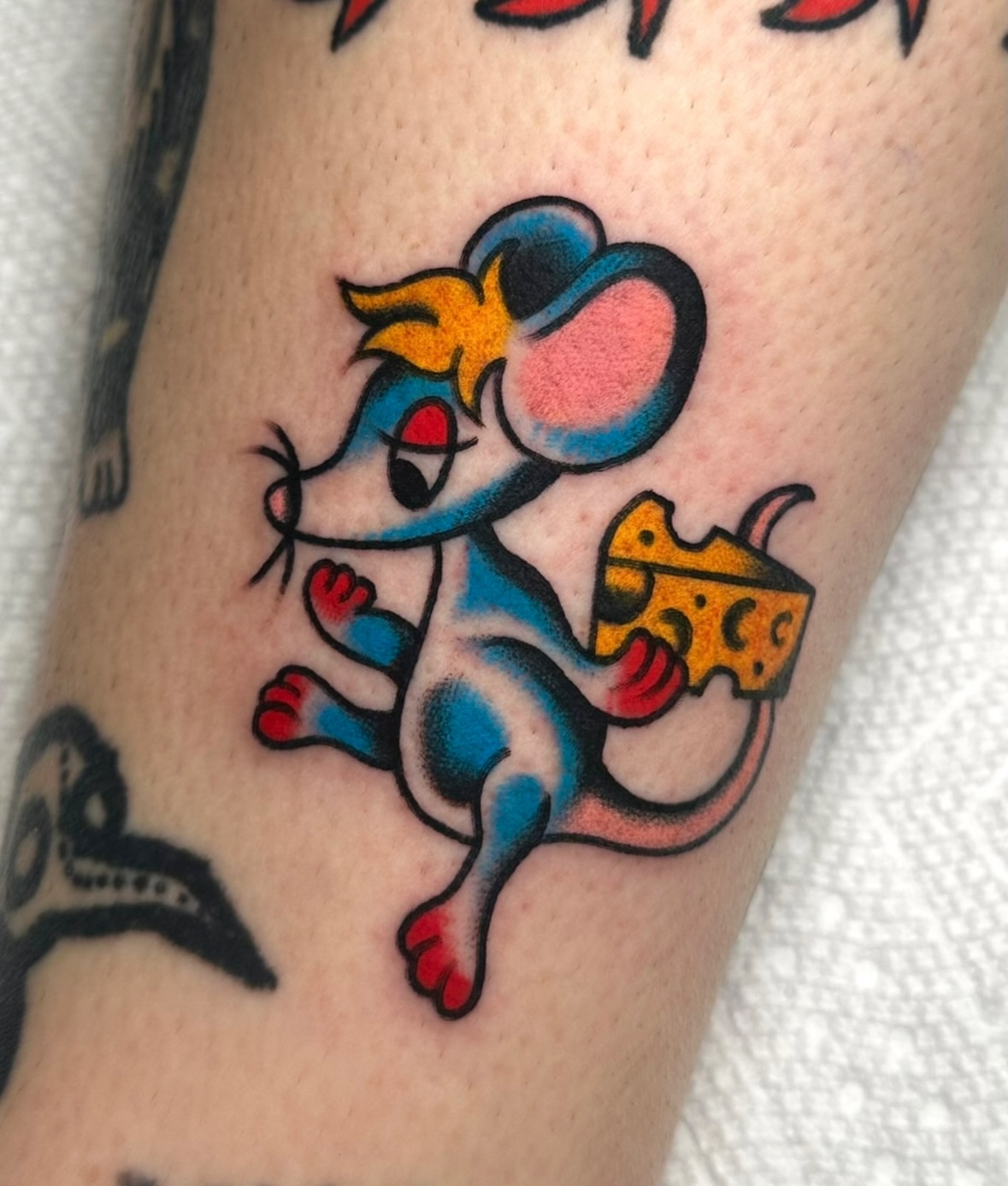 Mouse with cheese American traditional tattoo on the forearm by Zahra Niedermann