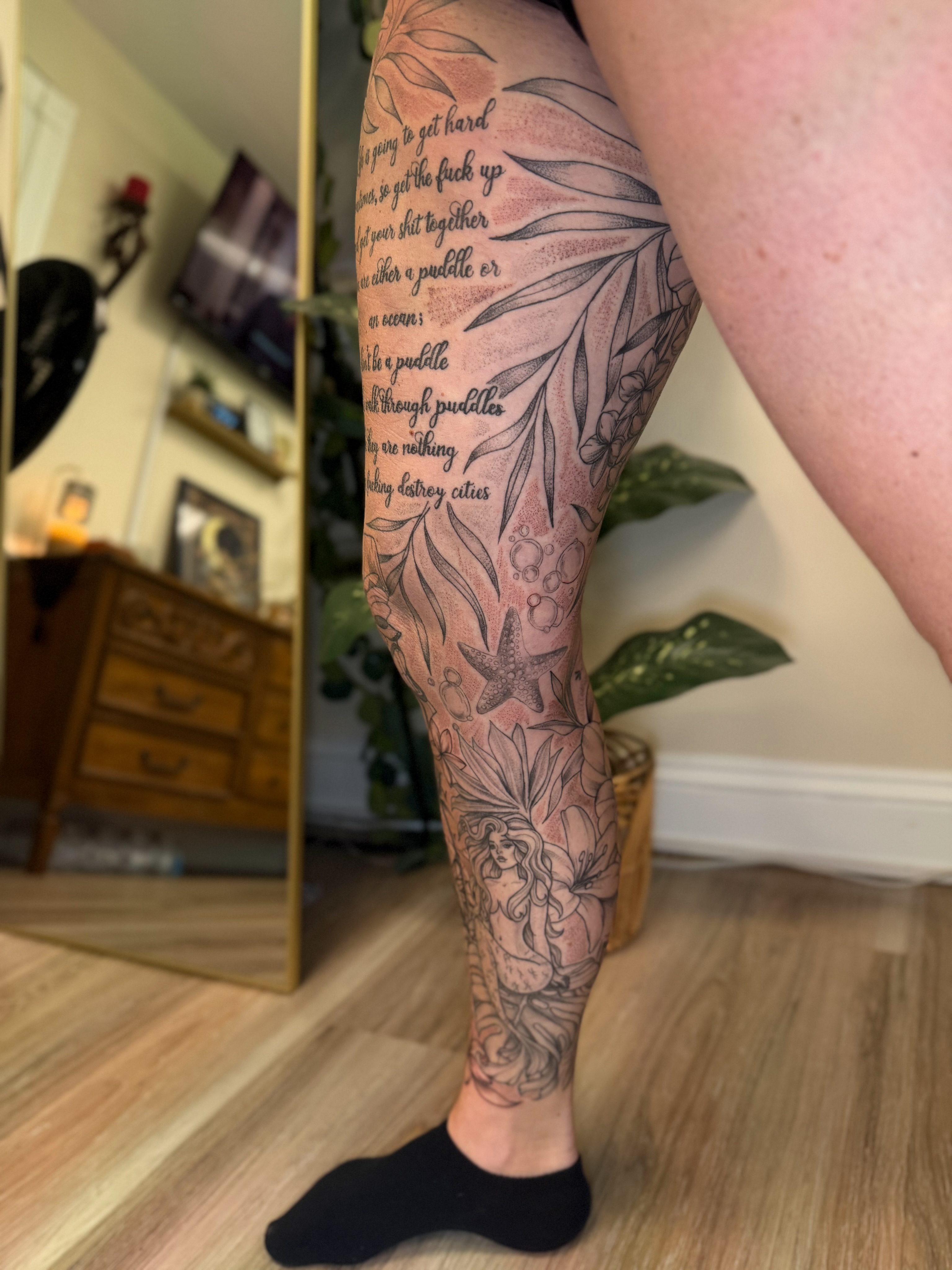 Mermaid and floral realism tattoo on the calf by McKenna