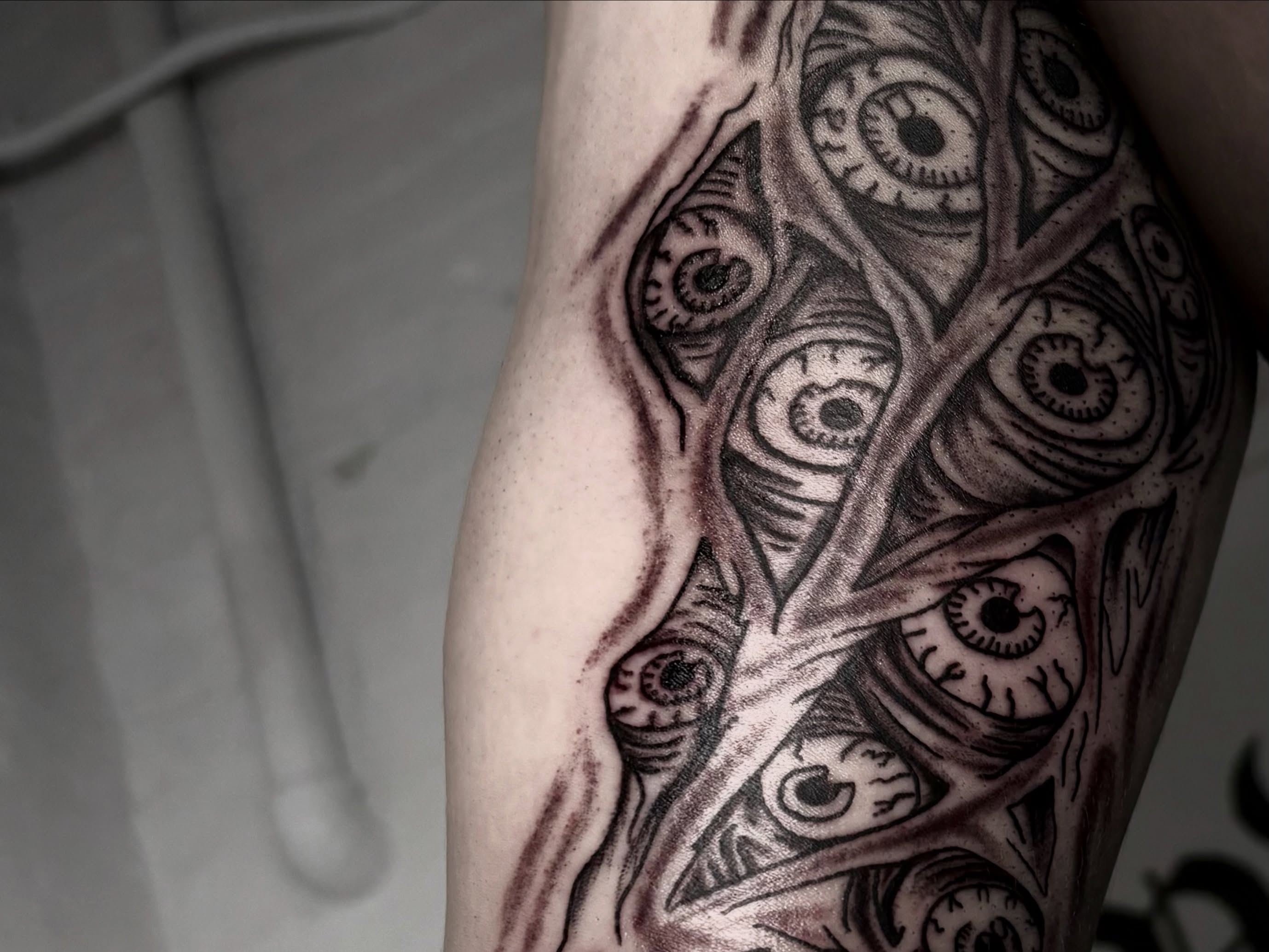 Eyes black and grey tattoo on the forearm by Landon Bagley