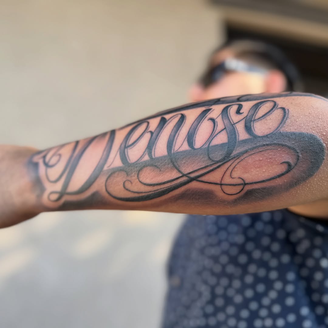 Denise lettering script tattoo on the forearm by Faith Lopez