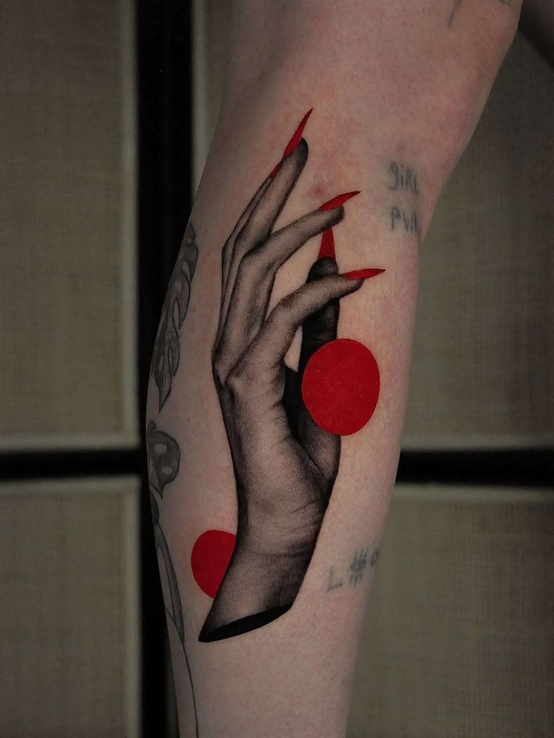 Hand with red nails and circles dotwork tattoo on the forearm by hiba ⊹ atlanta tattoo artist, Johns Creek, Georgia