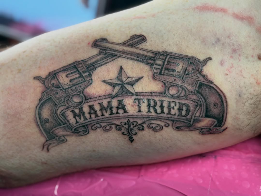 Two revolvers and banner with text tattoo on the forearm by Van Cleave Aesthetics, Franklin, Tennessee