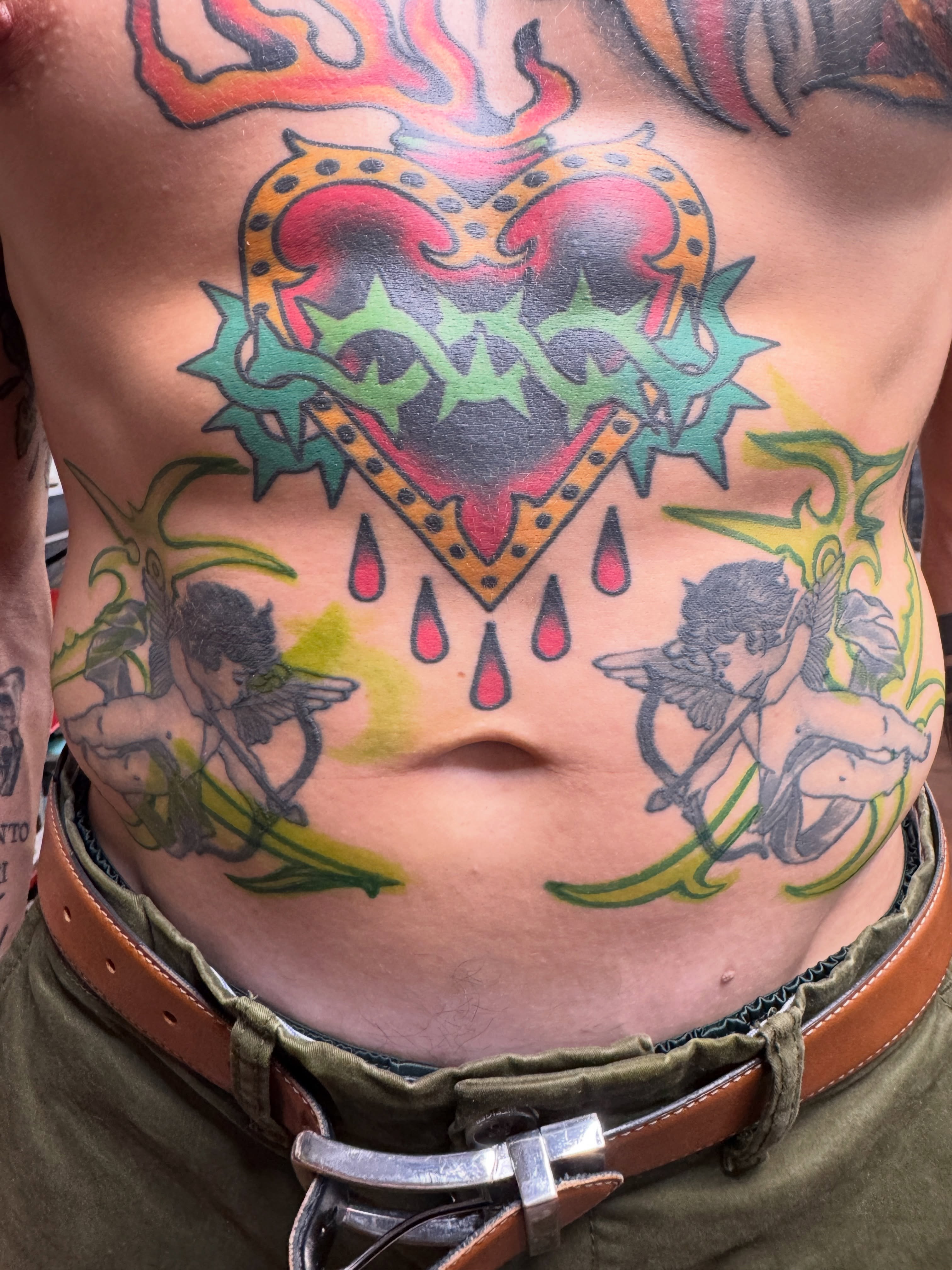 Heart with stars American traditional tattoo on the chest by Butch Mickle