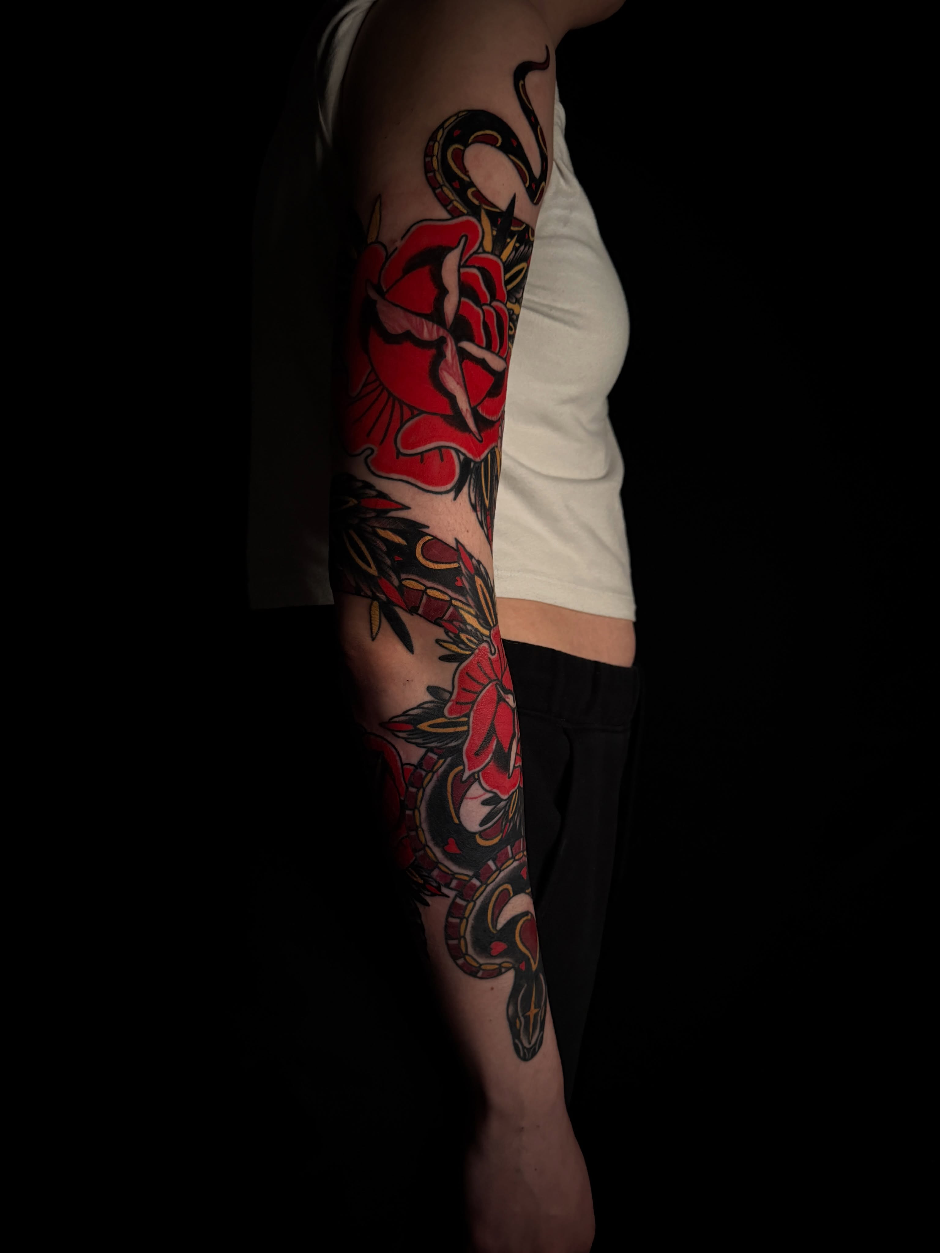 Snake and rose American traditional tattoo on the forearm by Brad Snow