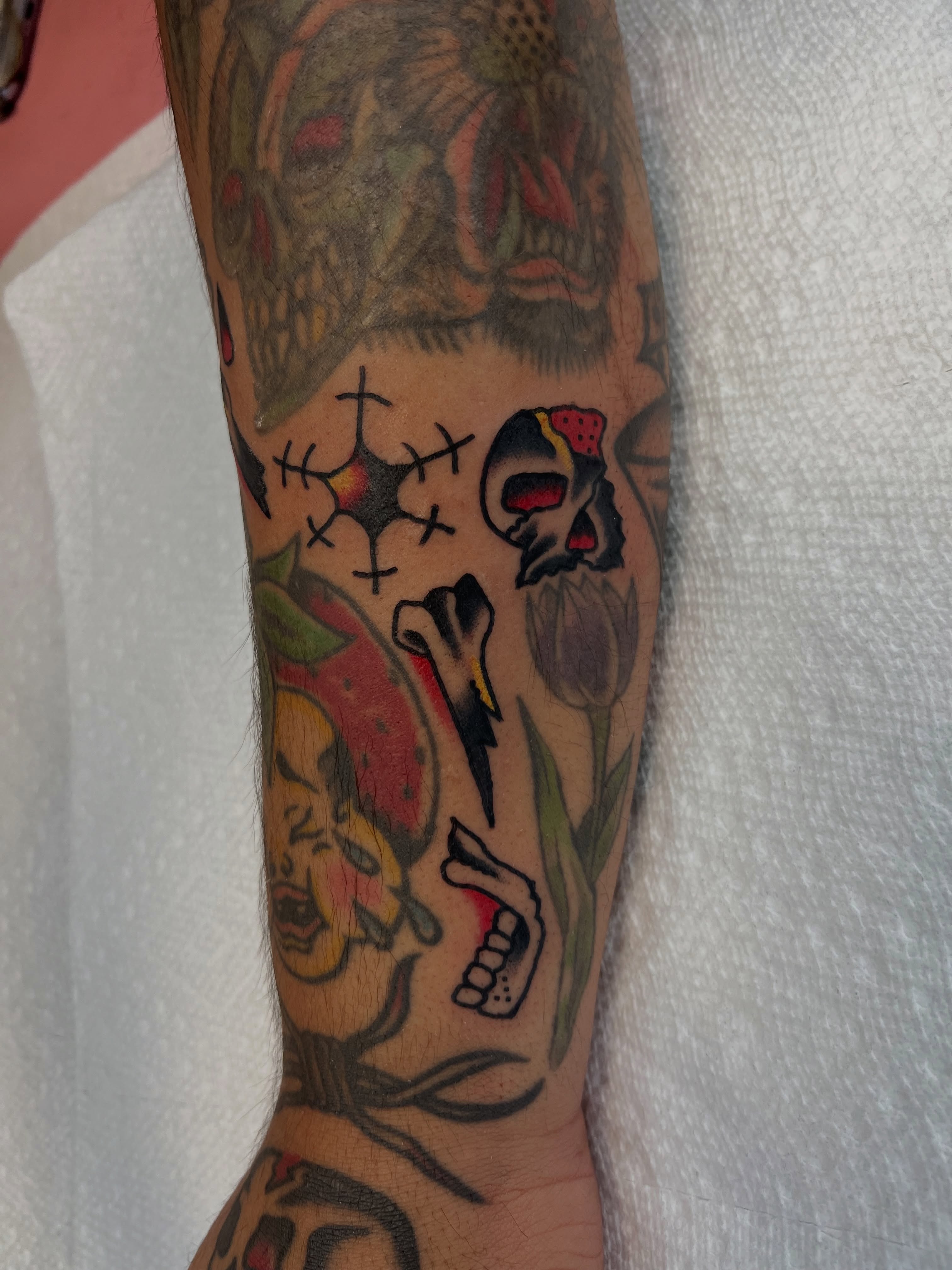 Skulls and tulips American traditional tattoo on the forearm by Nestor Zelaya