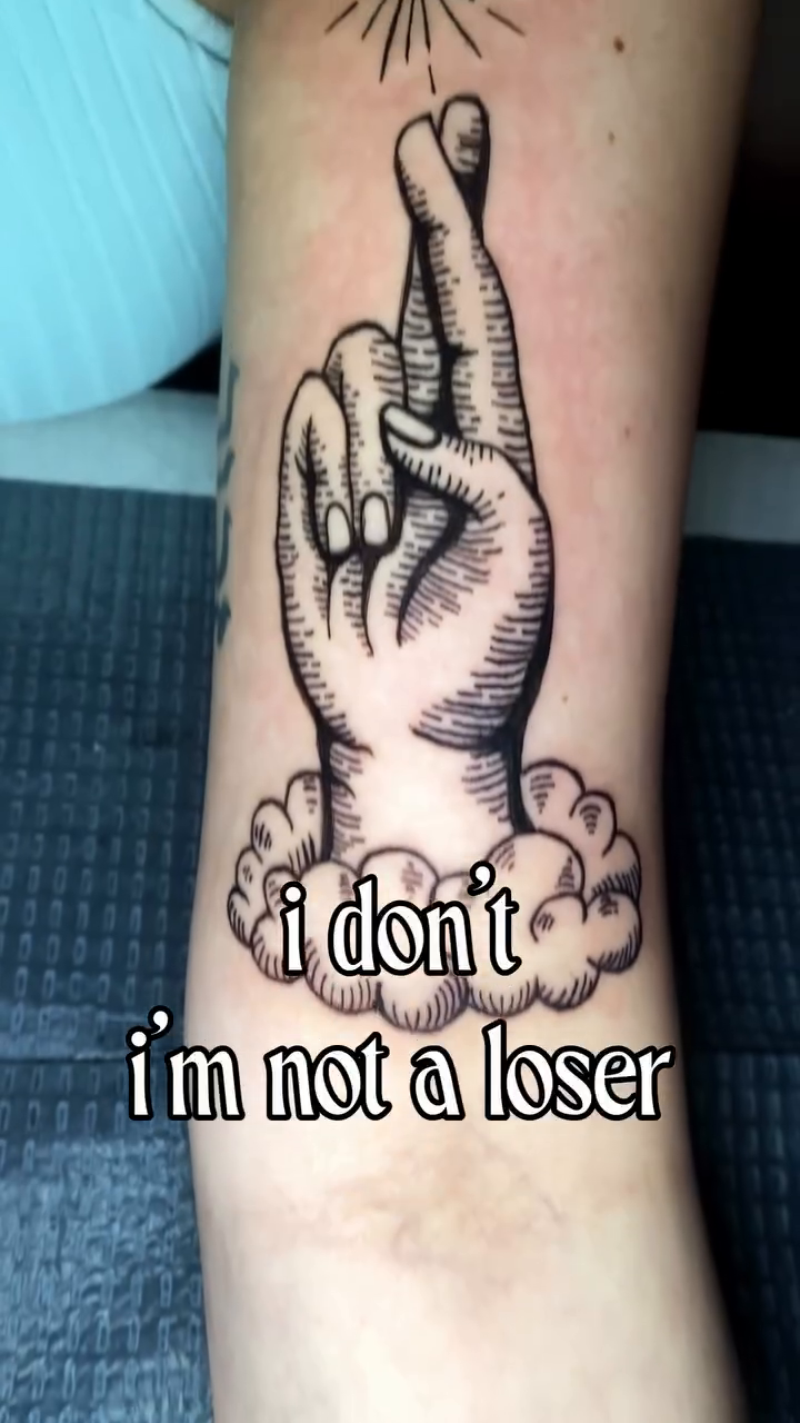 Fingers crossed with text minimalist tattoo on the forearm by Laura🦋