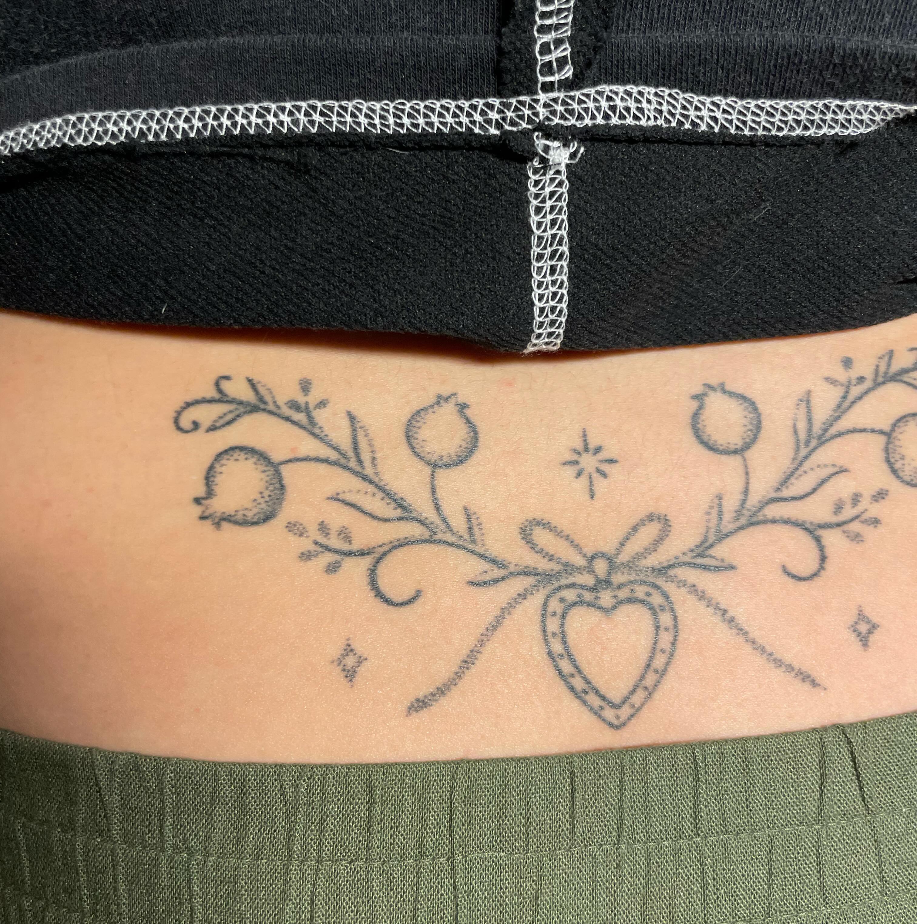 Heart and floral vine dotwork tattoo on the ribs by Quin