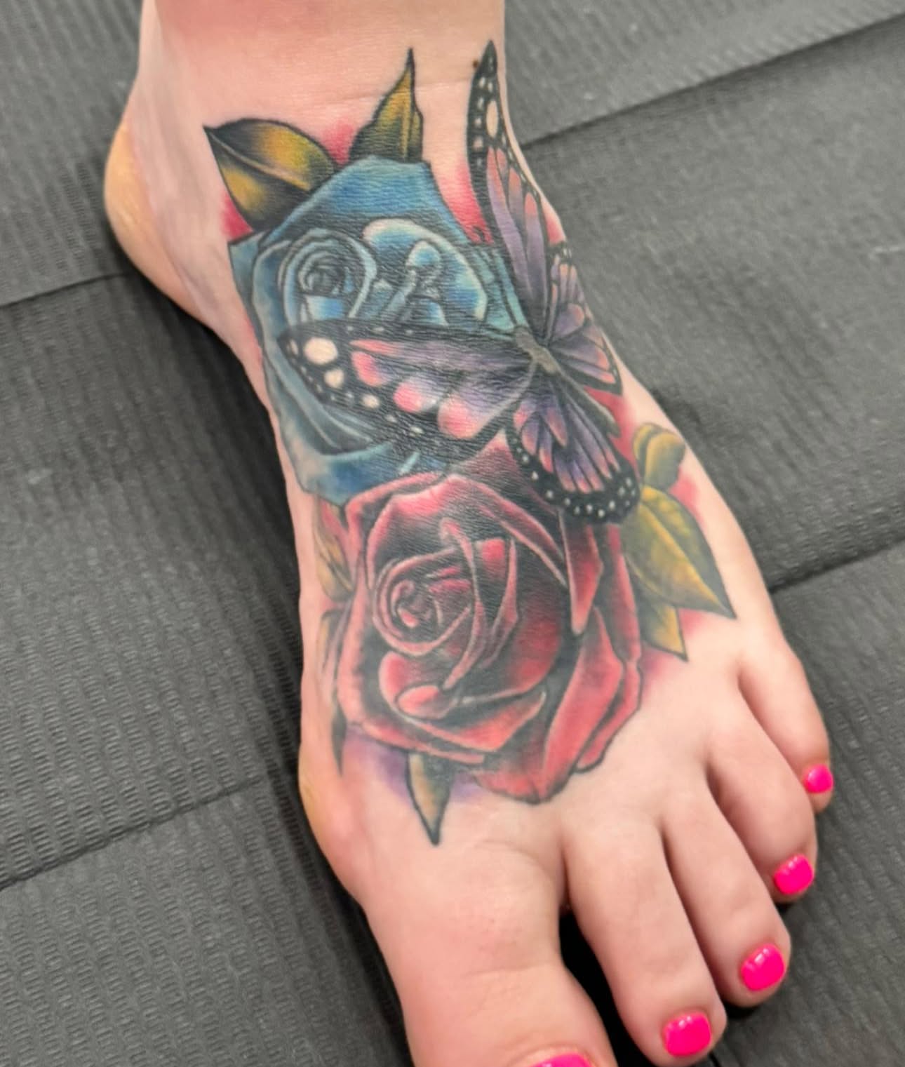 Rose and butterfly American traditional tattoo on the foot by Skott Kautman, Dubuque, Iowa