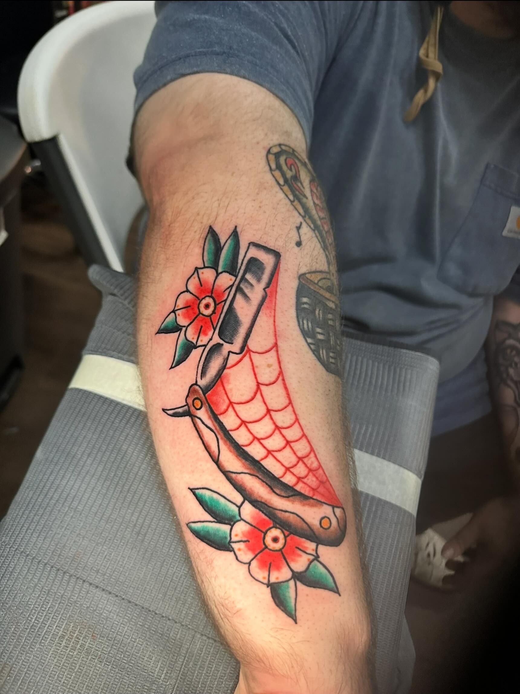 Snake and flowers American traditional tattoo on the forearm by Stephen Galena