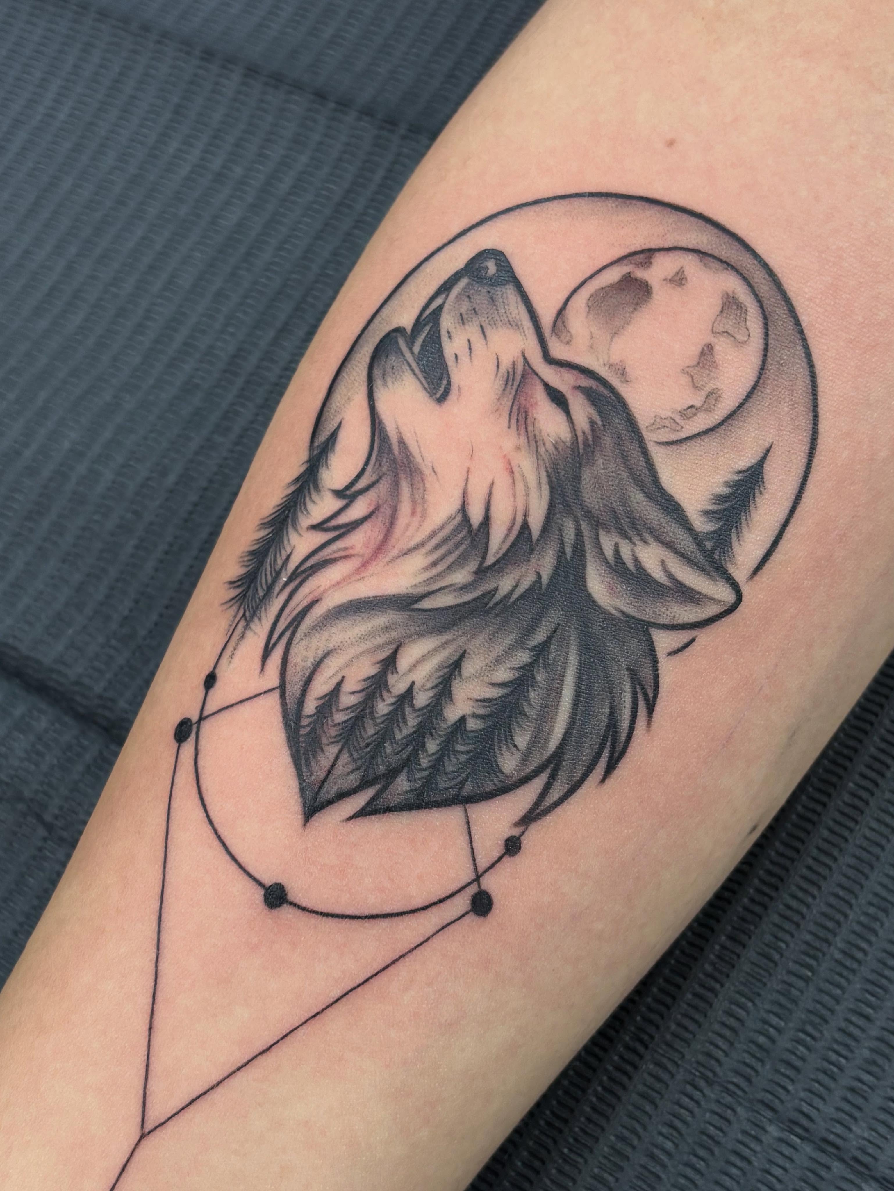 Wolf howling at moon realism tattoo on the forearm by Jennifer Flores